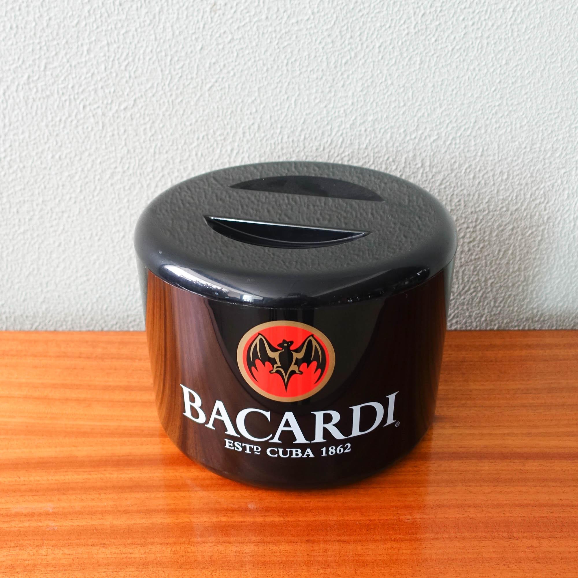 This ice bucket was produced by Diamond Photofoil Ltd, in Kent, United Kingdom, during the 1990's. It was a brand activation piece used in bars and discos to promote Bacardi. 
The ice bucket has a lid to close and maintain the temperature of the