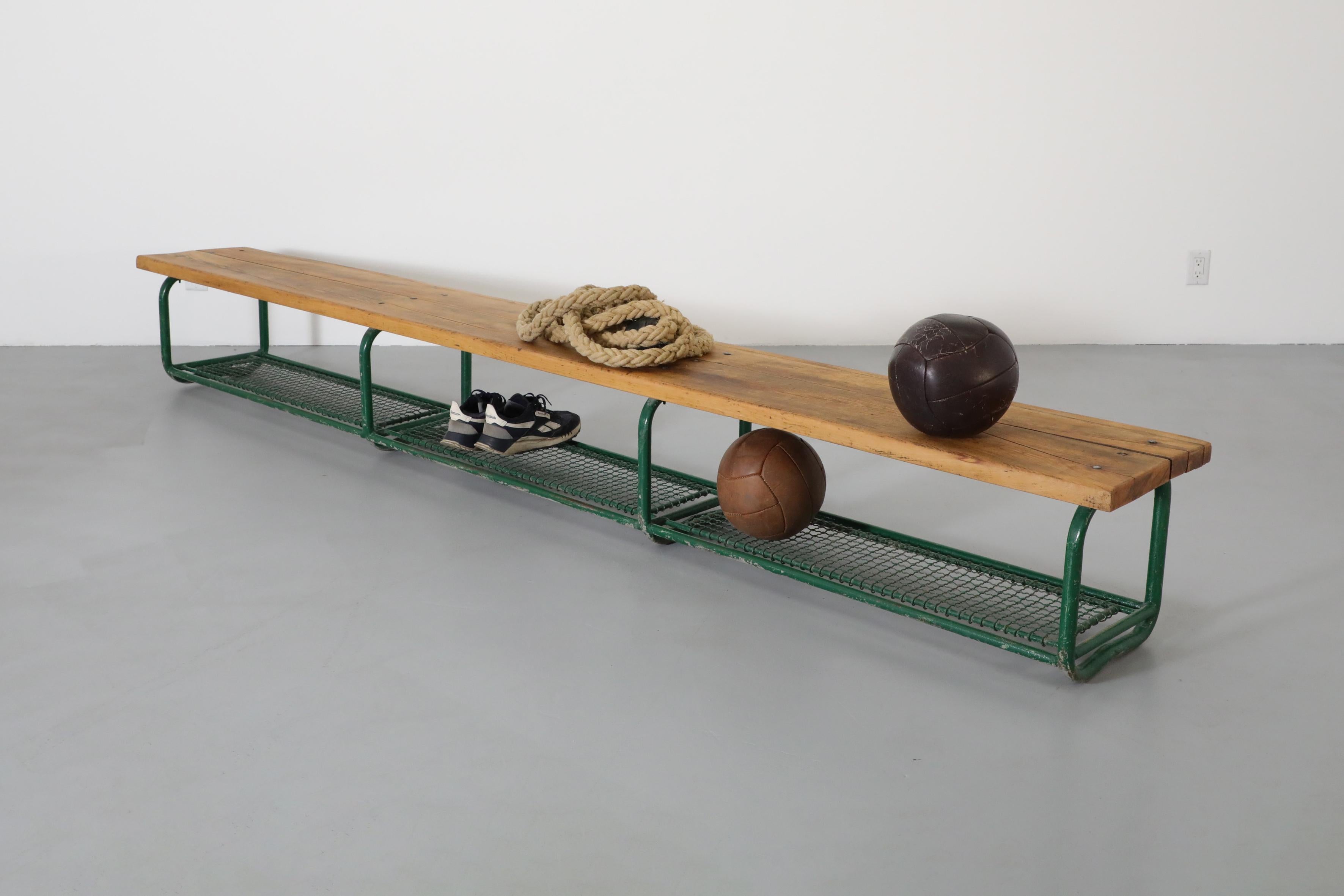 Vintage gymnasium bench with solid oak top and green enameled metal frame with lower shelf. Originally used for soccer matches and sporting these large benches are perfect for a long entry way or a protected and covered outdoor space. In overall