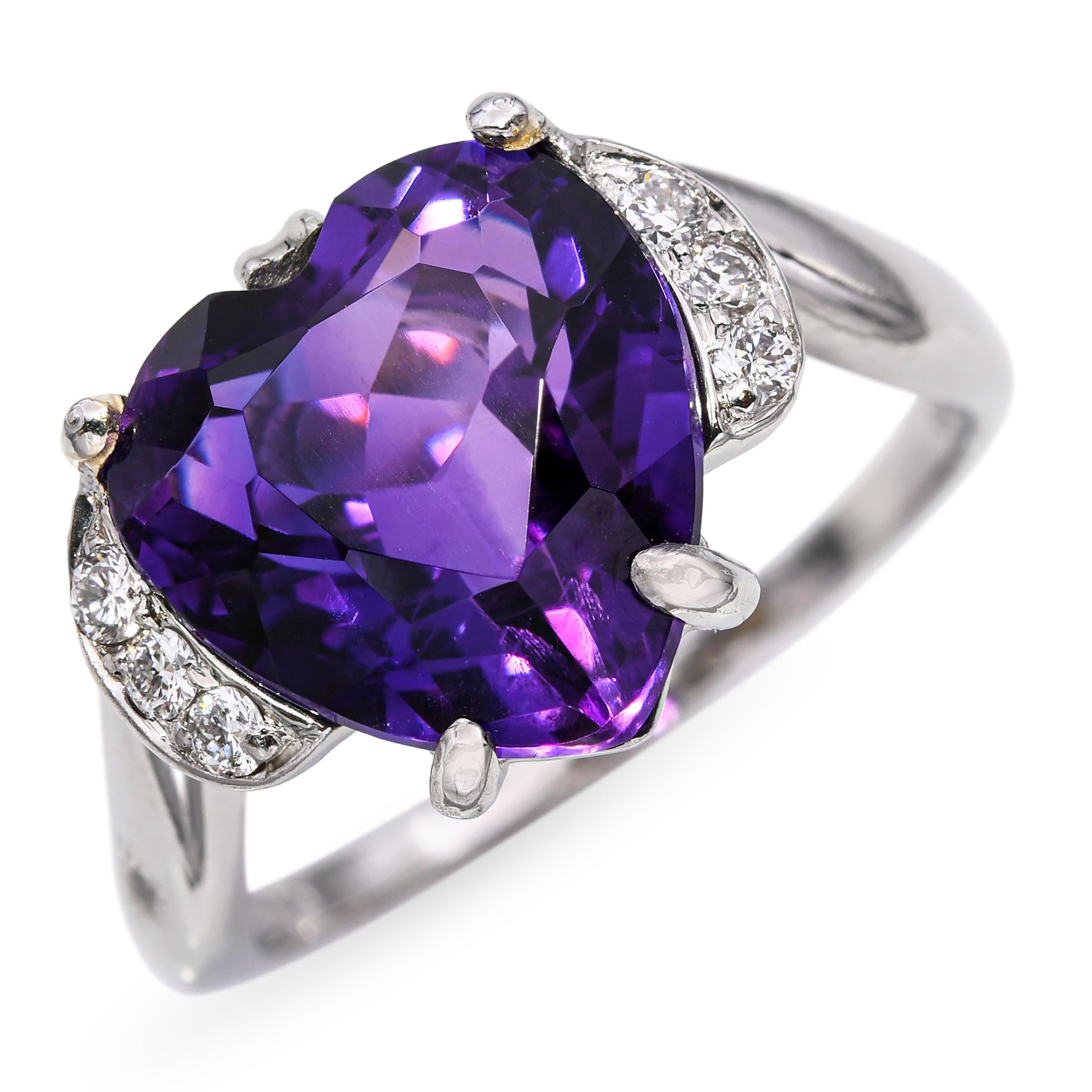 Dieser Vintage-Ring aus Platin zeigt ein romantisches Amethystherz, das von einem schimmernden, versetzten Diamanten akzentuiert wird. Der satte violette Farbton des Amethysts steht in schönem Kontrast zum Glanz des Diamanten und schafft ein