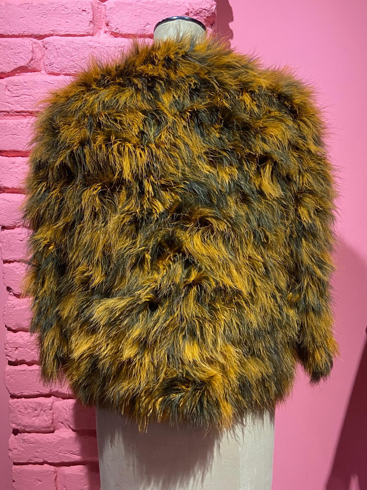 Siamo entusiasti di presentarti questa giacca Yves Saint Laurent Rive Gauche in piume di maribù dell'A/I 1981. Il capo presenta un mix di piume di maribù nere e arancioni bruciate, maniche leggermente tagliate e taglio appena sopra i fianchi. La