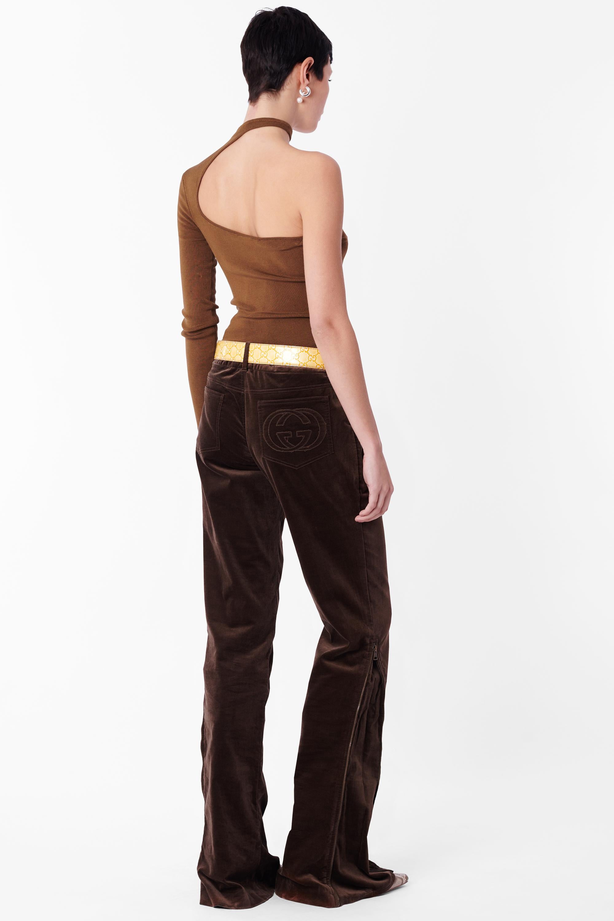 Pantalon taille basse en velours marron Tom Ford for Gucci Fall Winter 2003. Fermeture éclair sur chaque côté de la jambe, doubles poches plates zippées sur les hanches, jambe droite, deux poches arrière, logo Gucci GG en relief sur la poche arrière