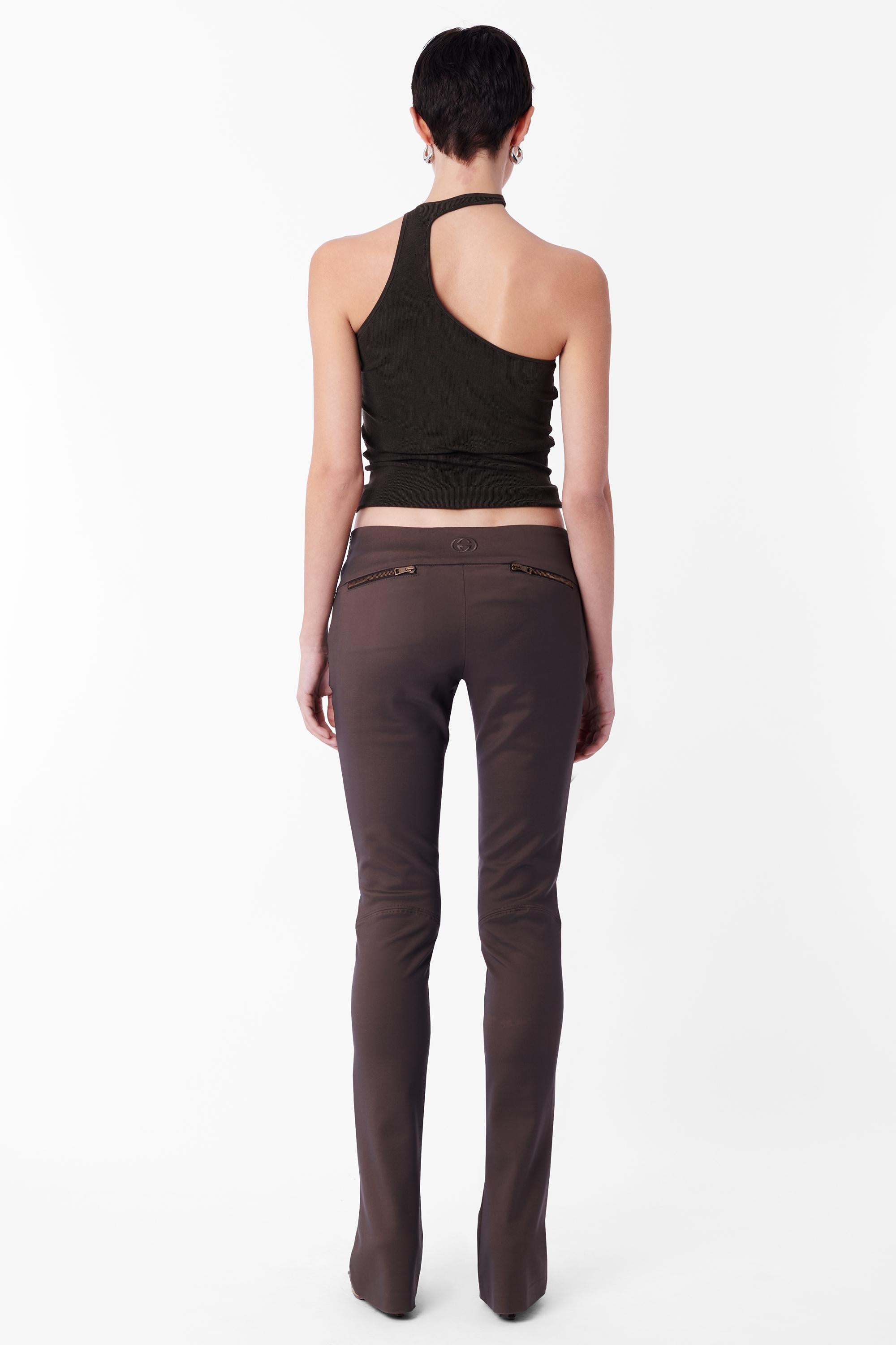 Tom Ford for Gucci Fall Winter 2003 low waisted brown trousers. Features cross-over v-front, double flat front hip pockets with zips, bootcut leg, double zip back pockets, embossed Gucci GG in black in centre back and invisible zip side closure. In