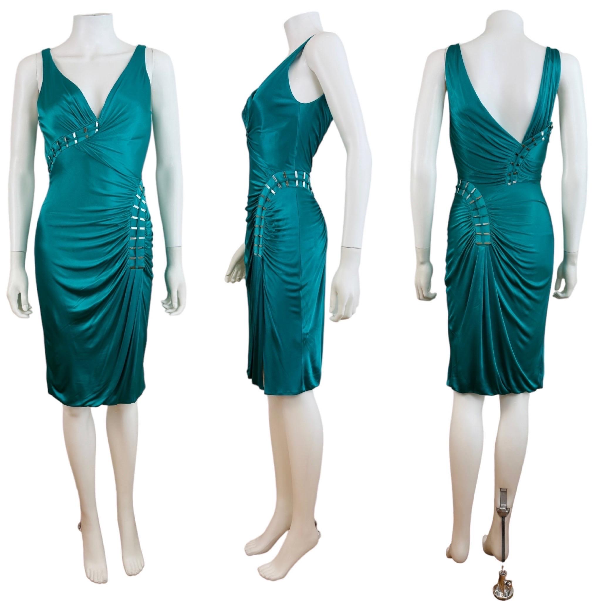 F/W 2009 Versace Dress
Emerald green slinky fabric with draped details throughout
Deep V neckline with gathered details at the bust + Versace stamped silver embelishments
Fitted wiggle style
Gathered details at the left hip w/Versace stamped silver