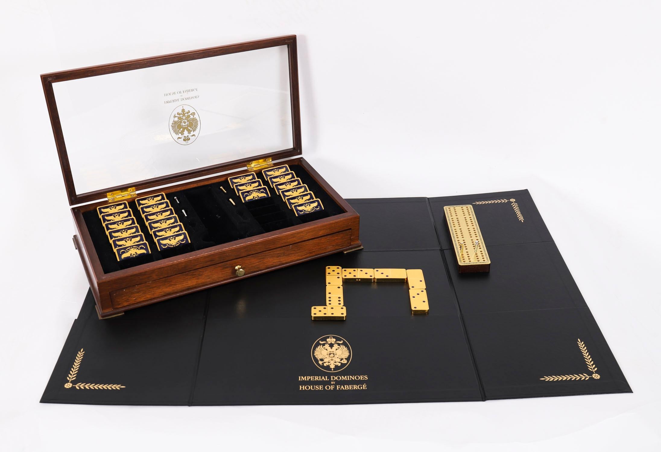 This is a wonderful vintage House of Faberge 22 carat gold plated & enamel walnut cased set of dominoes, made by the Franklin mint, late 20th century in date.
 
The set comes complete with 28 minted dominoes plated in 22 carat gold and blue enamel