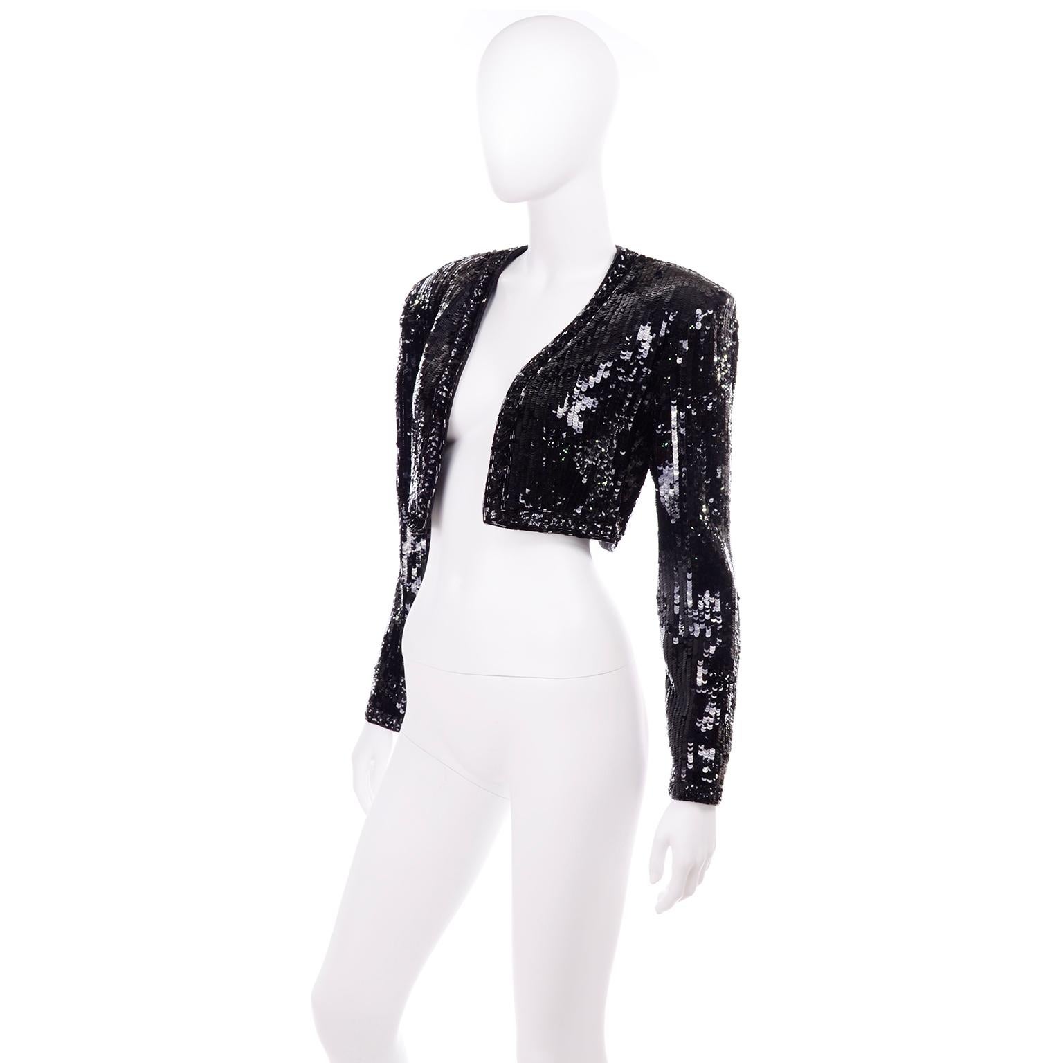 This is a vintage 1980's Fabrice Silhouette cropped black sequin evening jacket that would be perfect to wear over your evening dress! The shell is 100% silk and the lining is 100% rayon. There are shoulder pads and there is beautiful beading and