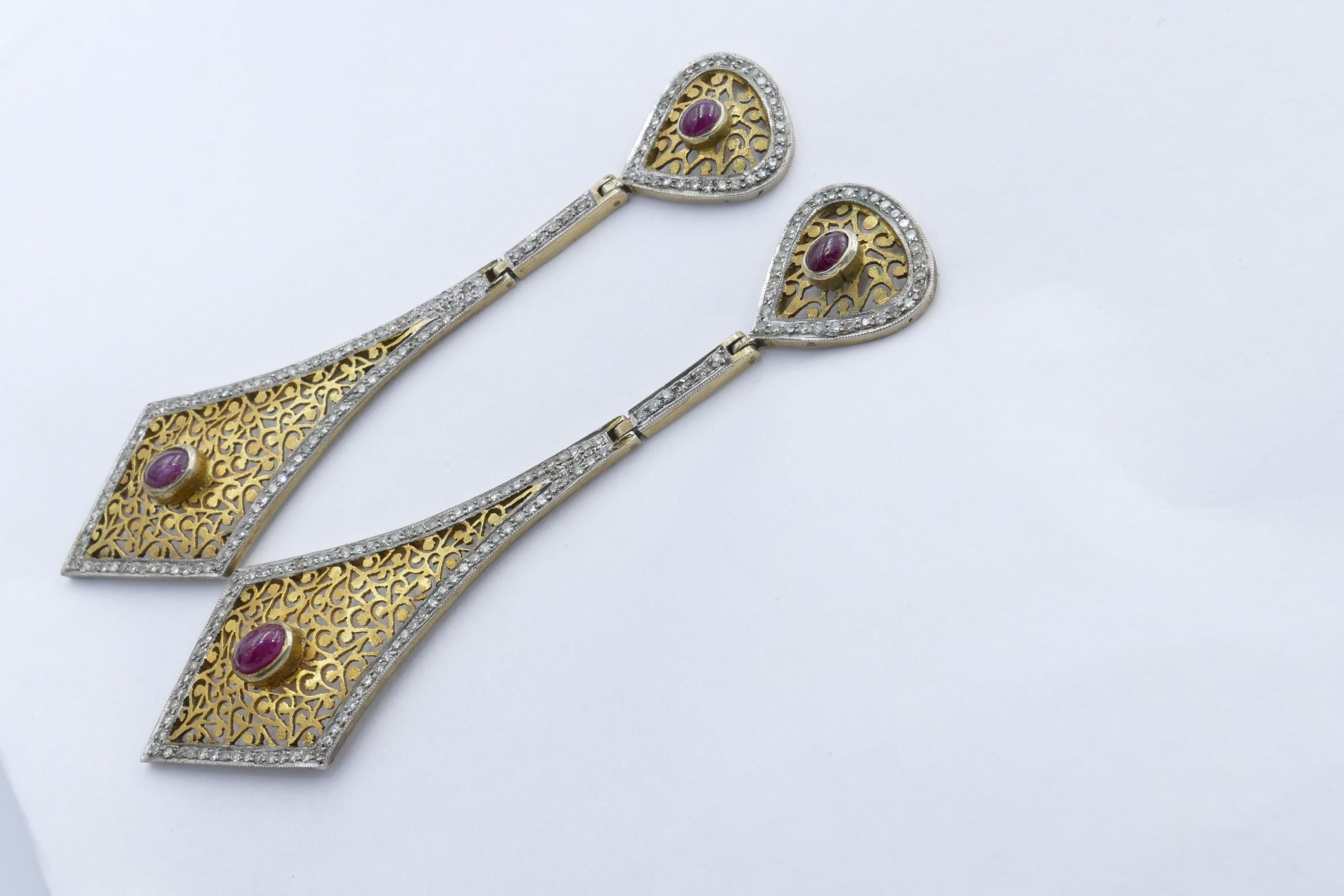 These are simply gorgeous! A long 93mm in length they are very sure to attract attention.
4 cabochon cut natural Rubies bezel set in Yellow gold sit at the top with  249 single cut Diamonds pave set at the outer frame of the filigree pendant.
Good