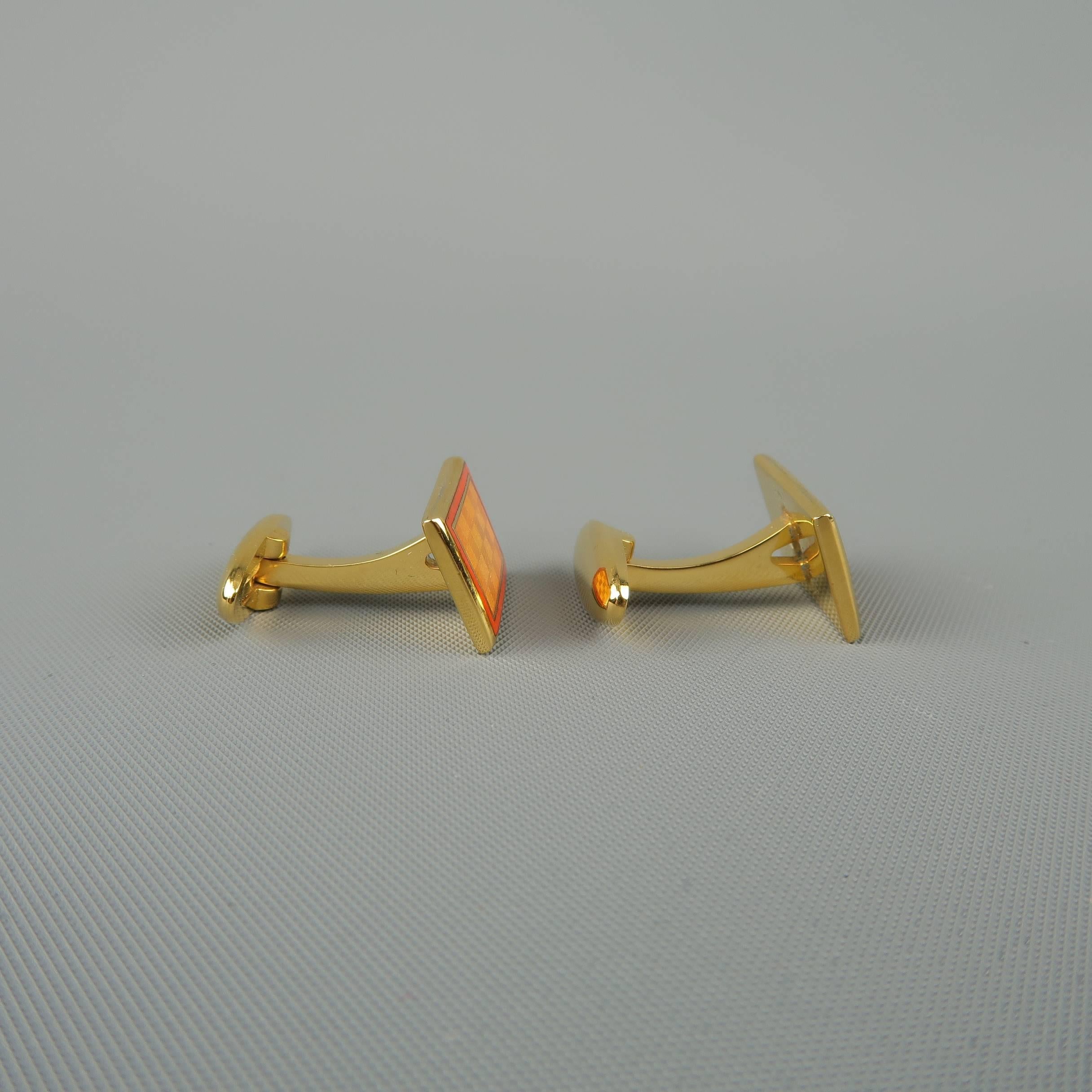 Vintage FACONNABLE cuff links come in yellow gold tone metal with orange enamel checkered motif. With case.
 
Good Pre-Owned Condition.
