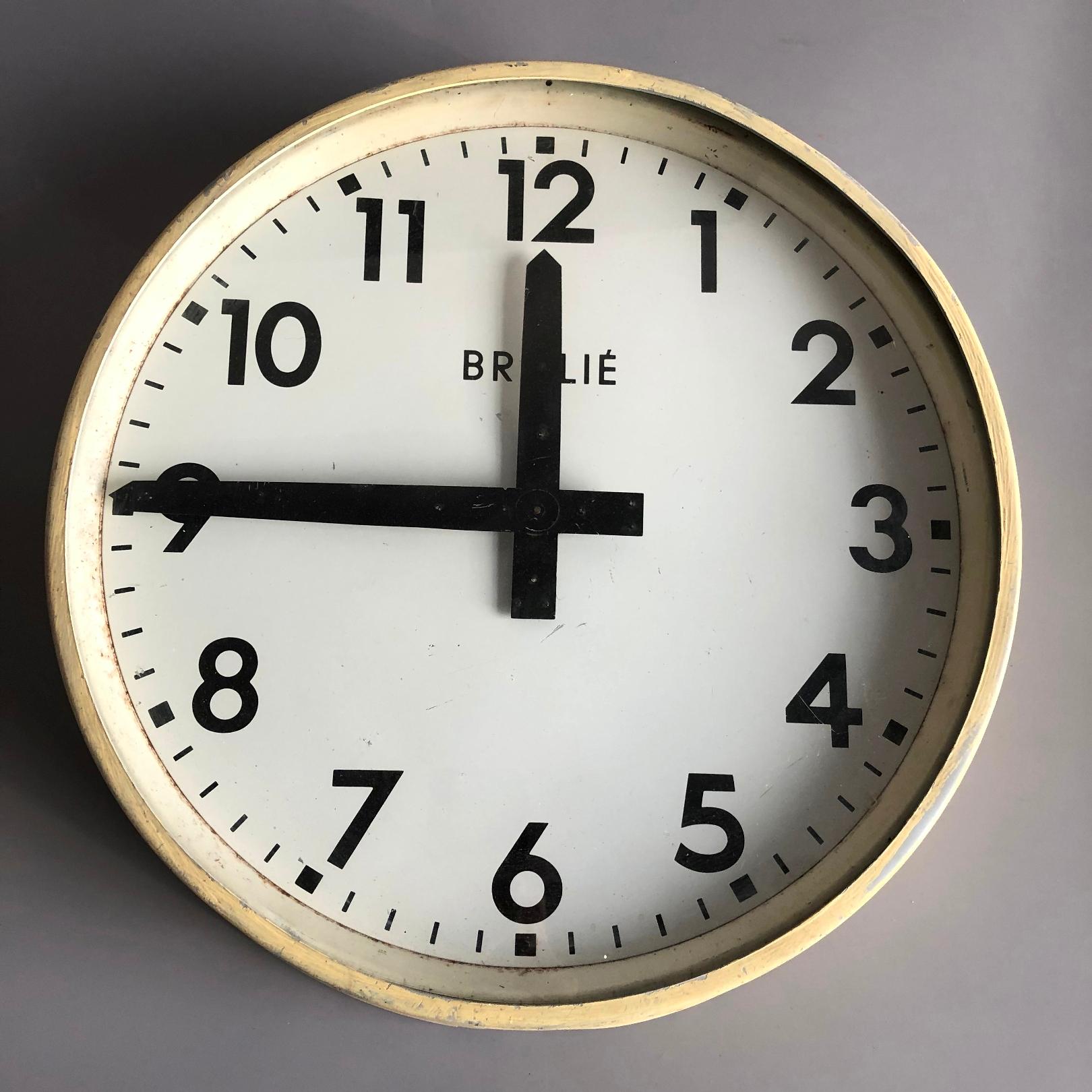 Wall clock by Brillié wqs used in a factory. Clock has a brass mechanical movement. The electric mechanism on the back seems to be in tact but working ability has to be checked.