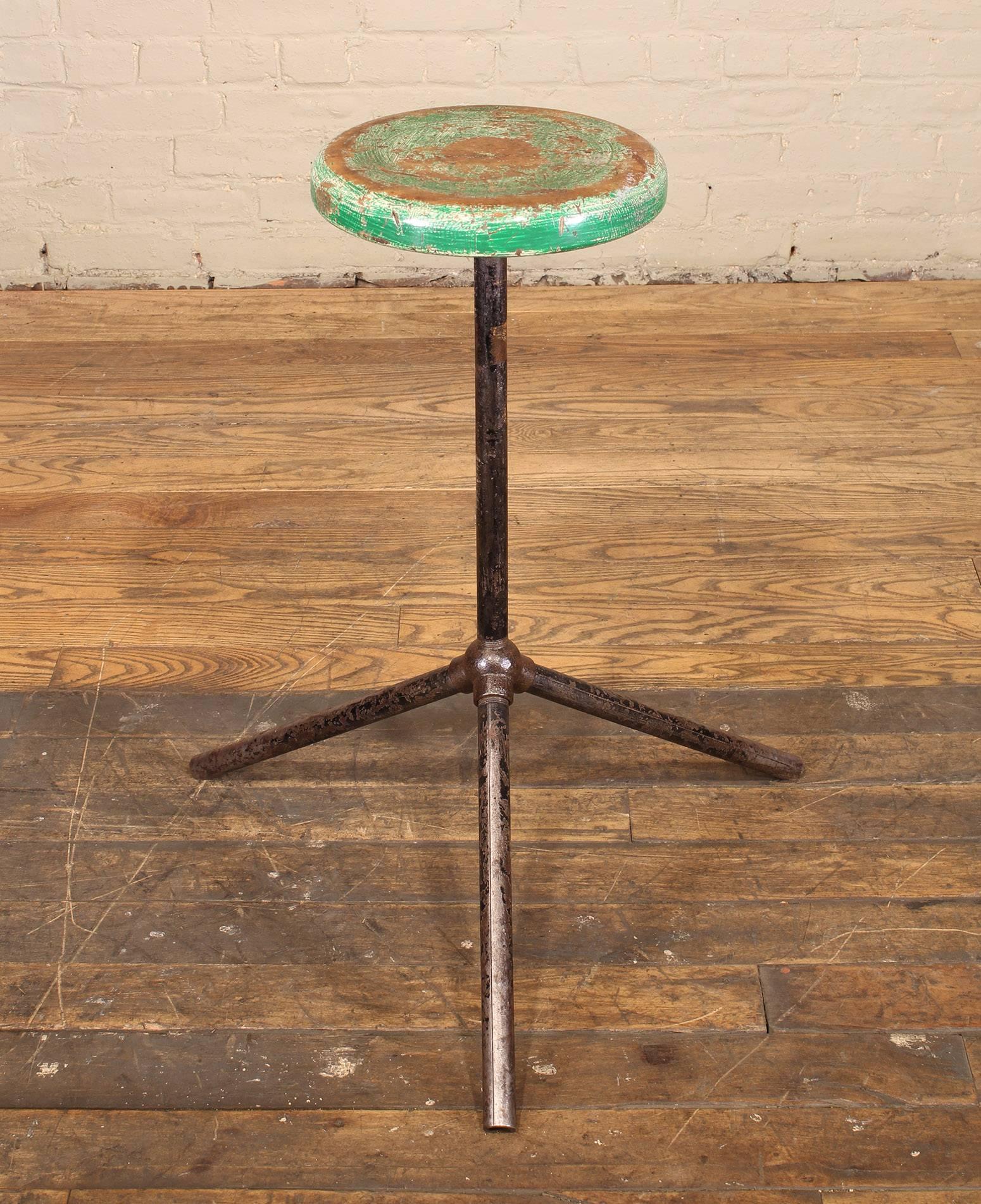 Vintage steel and distressed wooden factory shop stool, Industrial style with three steel poles and cast iron bubble pipe joint. Seat measures 11