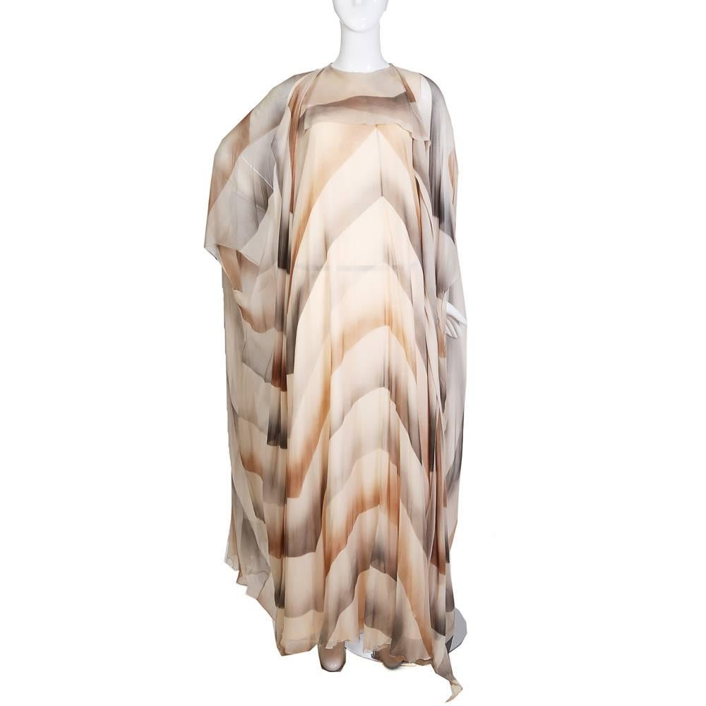Vintage caftan by unknown designer
Sheer silk with grey and beige large scale chevron gradient pattern
Nude lining underneath
Top hook and eye in the back
Condition: Great
Size/Measurements:
42