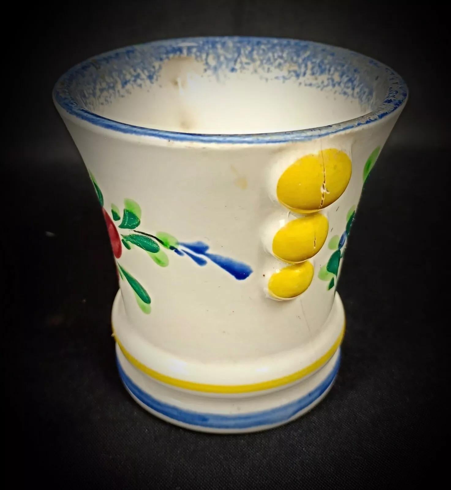 This vintage faience pot by M.F.A Pornic Dinard features a charming Breton and floral design, reflecting the rich cultural heritage of France. The pot is in good condition for its age, with minor signs of wear, including slight wear on the