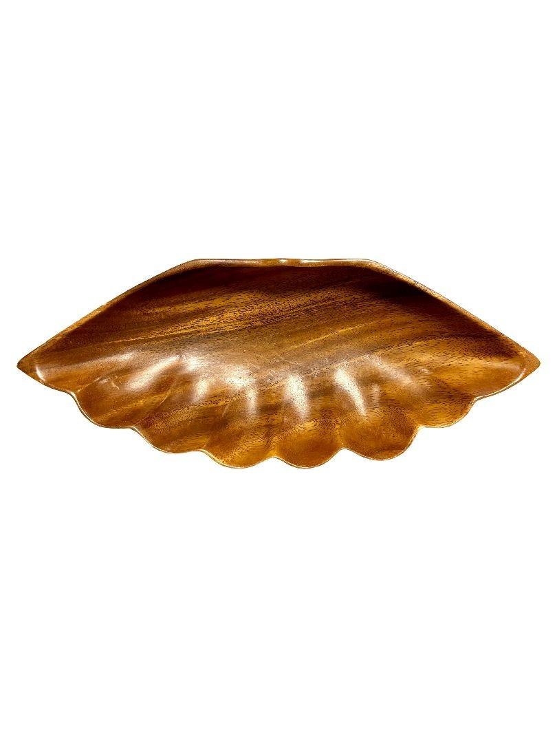 Elevate your decor with this carved wood clam shell tray by Fair Craft. Its intricate leaf design exudes classic elegance. Perfect for organizing or displaying, this timeless piece adds vintage charm to any space.

Bring home a touch of nostalgia