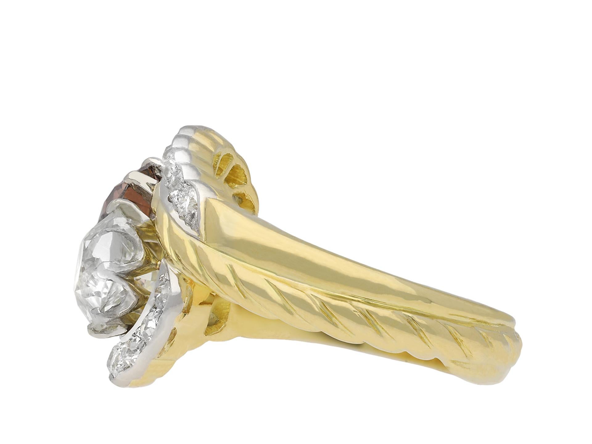 Vintage fancy coloured diamond crossover ring. Diagonally set with one round old cut natural unenhanced cognac coloured diamond in an open back claw setting with an approximate weight of 1.35 carats, and one round old cut diamond in an open back