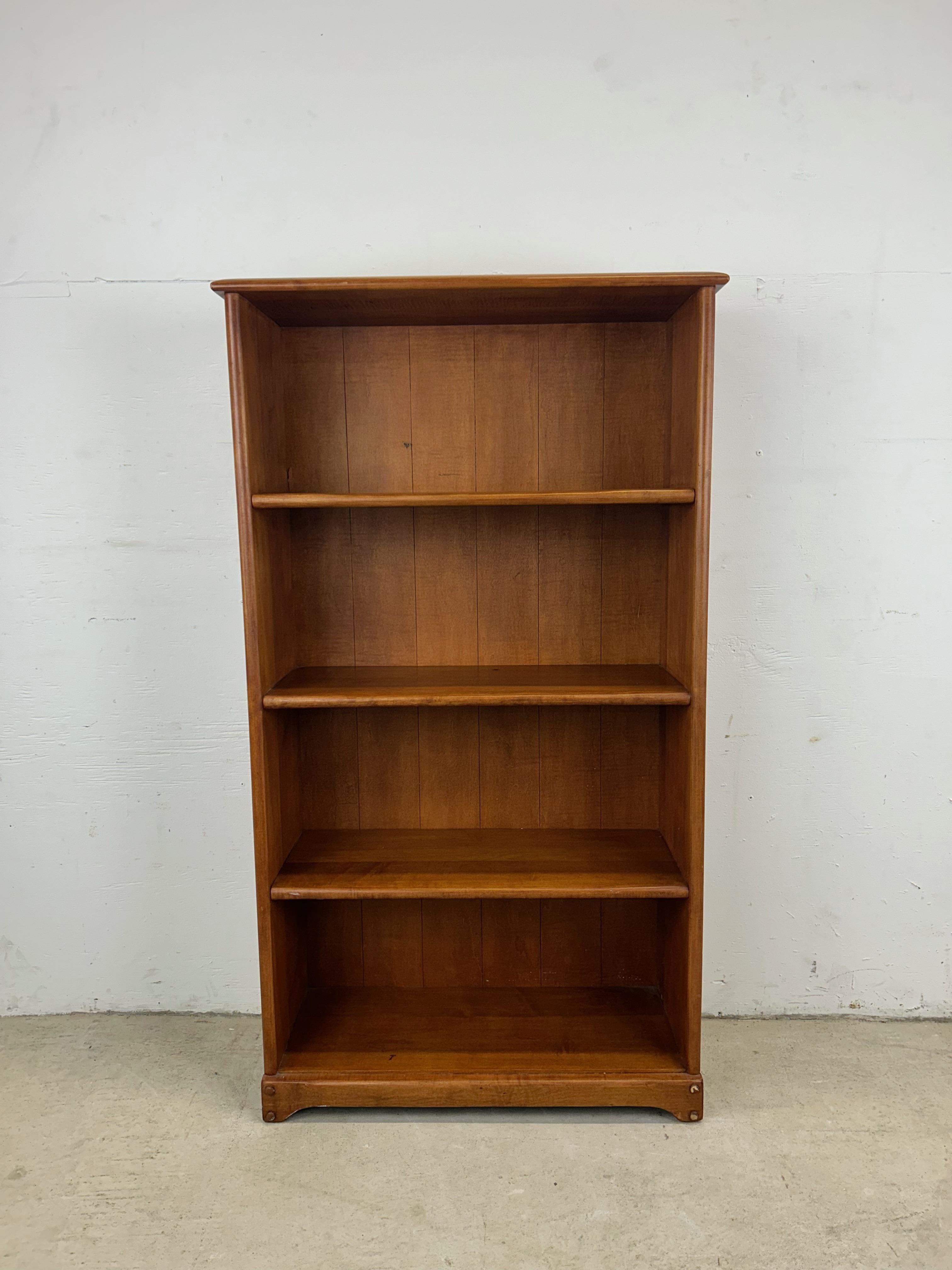 This vintage farmhouse style bookcase features solid maple construction with original finish, four shelves with open storage, and sculpted base with peg accents.  Similar smaller farmhouse style bookcase available separately.

Dimensions: 26w 10.75d