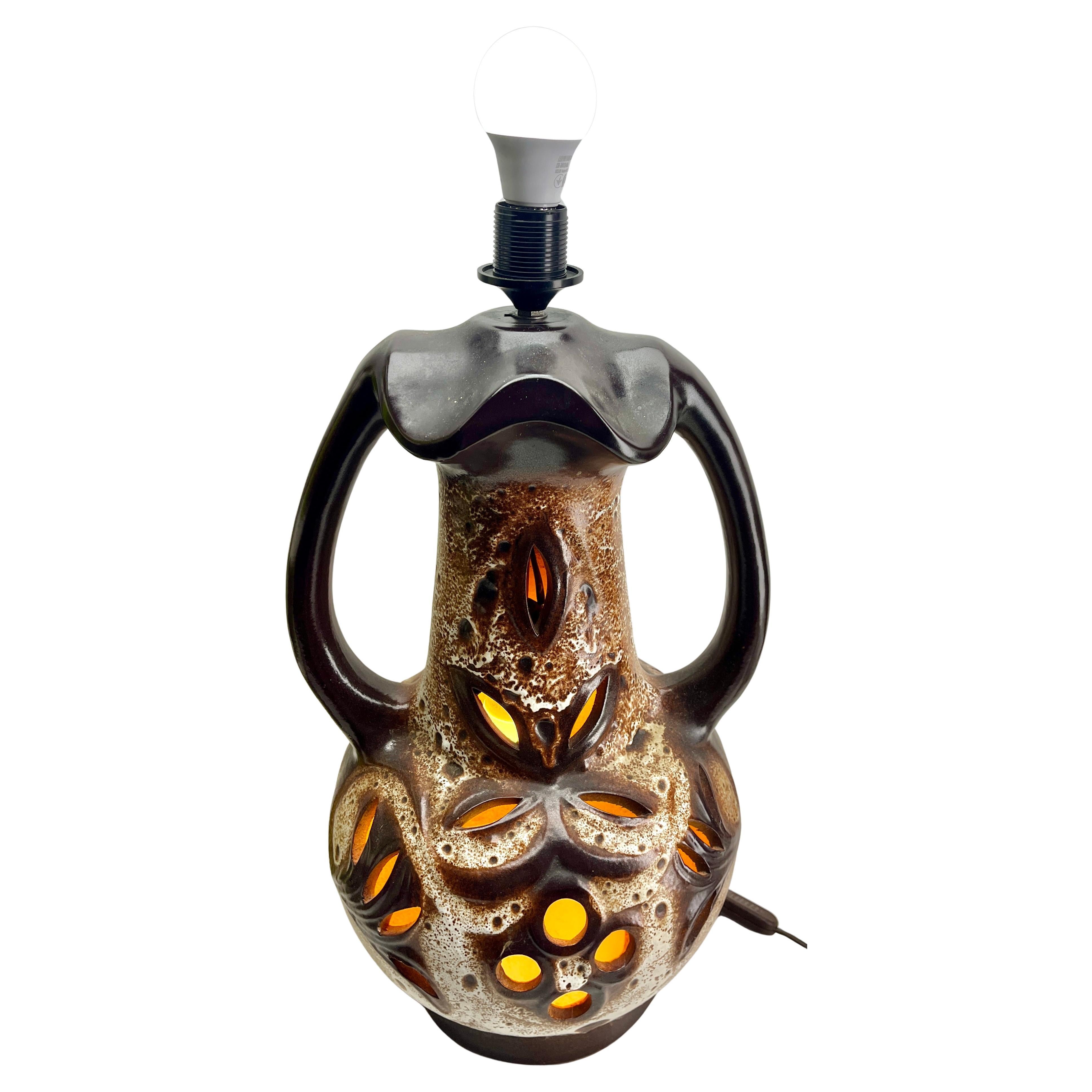 Drammatica lampada da terra in lava grassa con smalti verdi e marroni su fondo neutro in gres, con collo stretto, base sovraccarica e due manici bisecati. Due luci in una, con una lampada standard sulla parte superiore e una lampada interna