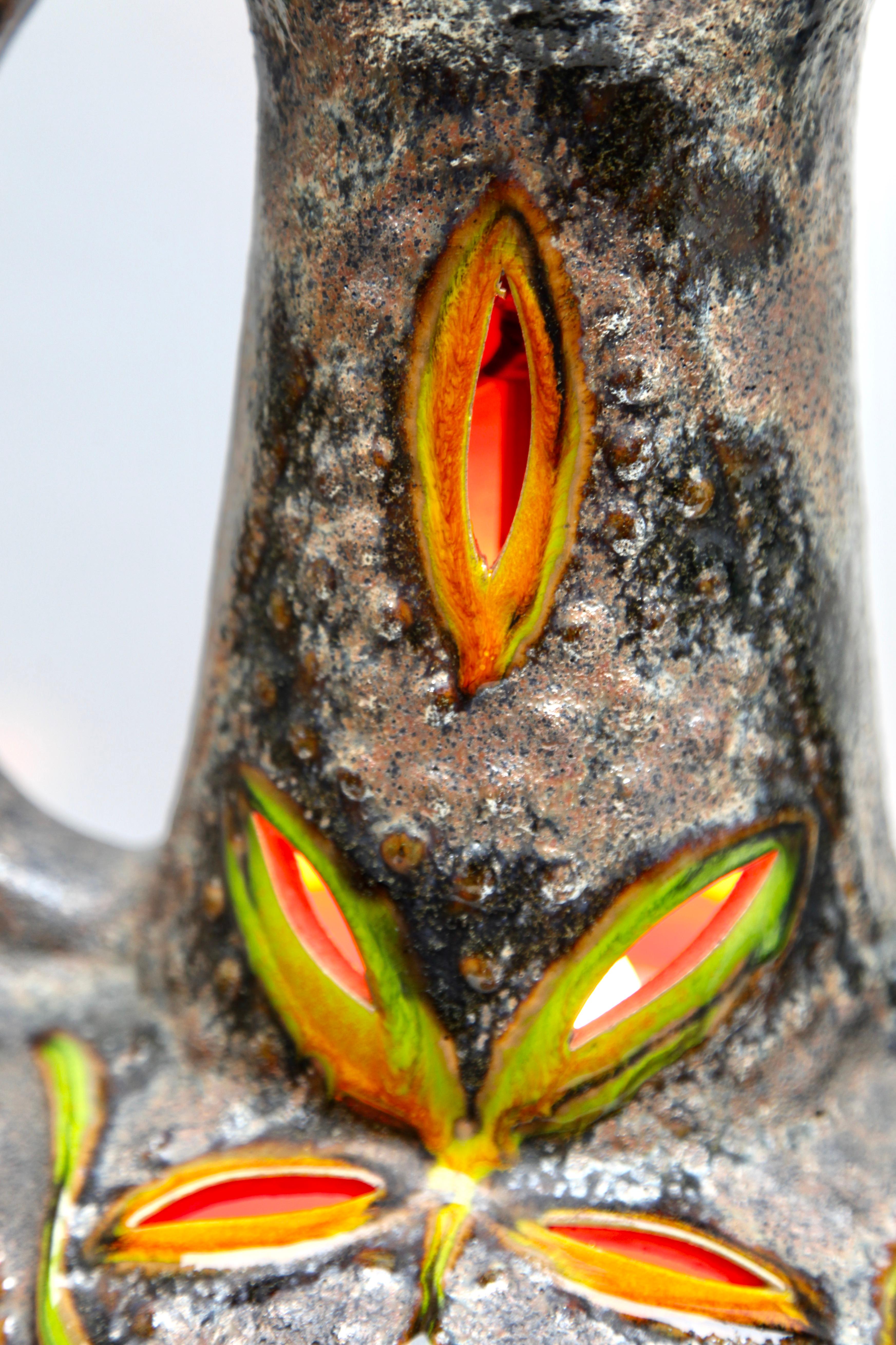 Dramatische Stehlampe aus fetter Lava mit grüner und orangefarbener Glasur auf neutralem Steinzeuggrund, mit schmalem Hals, überladenem Sockel und zwei halbierten Henkeln. Zwei Leuchten in einer, mit einer Standardlampenfassung oben und einer