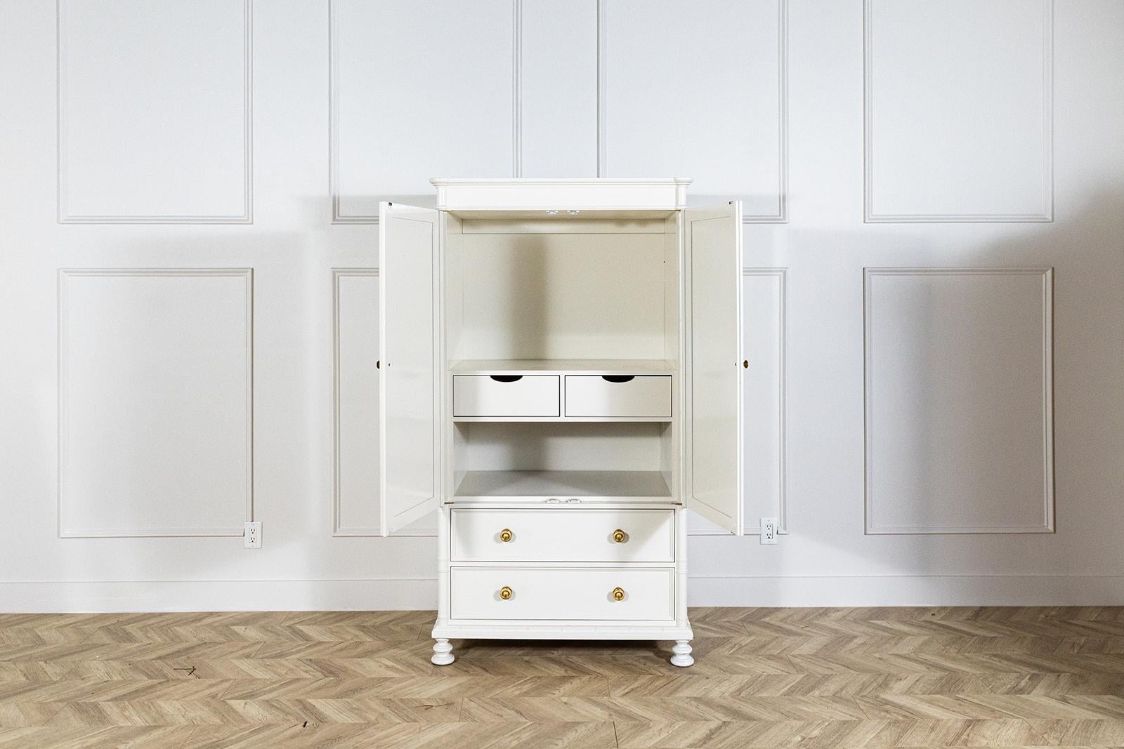 This lovely faux bamboo armoire from Baker Furniture was built as an entertainment cabinet in the late 20th century. It has been refurbished as an armoire and has been professionally lacquered Sherwin Williams White Duck,  which is a lovely