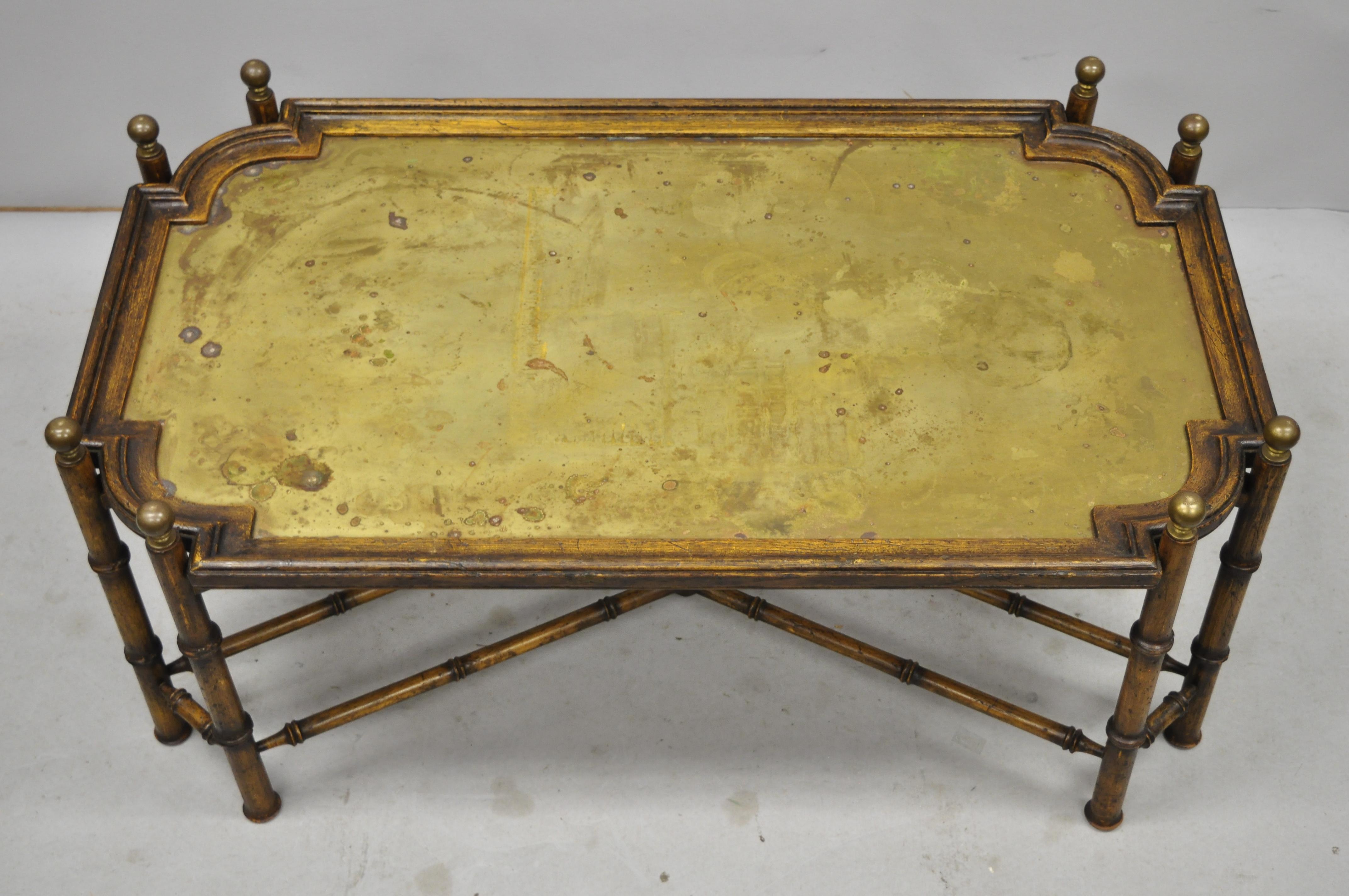 Vintage faux bamboo Chinese Chippendale style brass tray top coffee table. Item includes a faux bamboo oakwood base, removable brass tray top, brass finials, cross stretcher base, distressed finish, great style and form, circa mid-late 20th century.