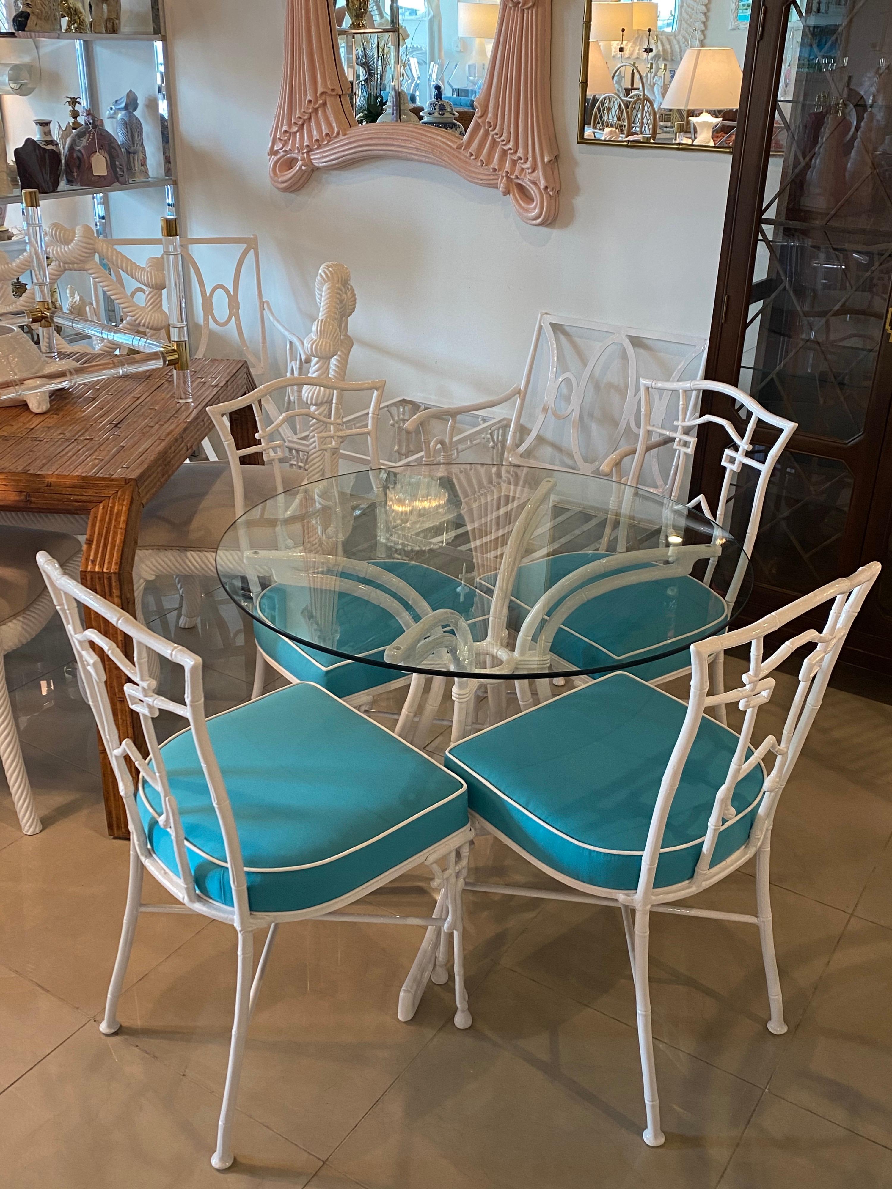 Beautiful vintage faux bamboo, greek key, metal 5 piece outdoor patio dining set. This set has been newly, professionally powder-coated in a white gloss. The cushions have been newly made, custom with Sunbrella fabric and trim. The glass is just to