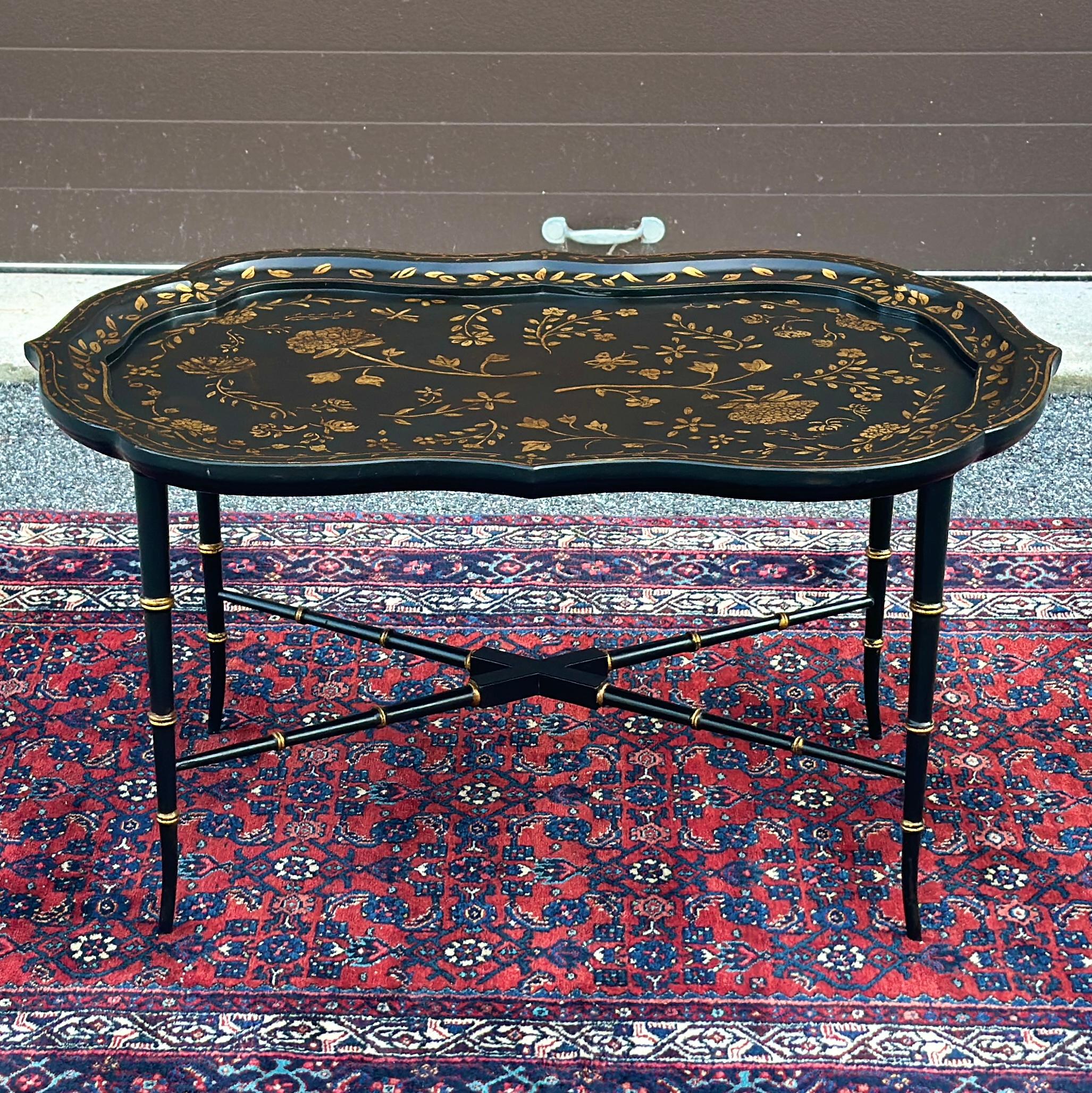 Vintage scalloped edge coffee table with hand painted gold floral design on elegant faux bamboo base with x stretchers and flared feet. Tray top in the style of antique paper mache tray tables however fixed to the base and not removable. 