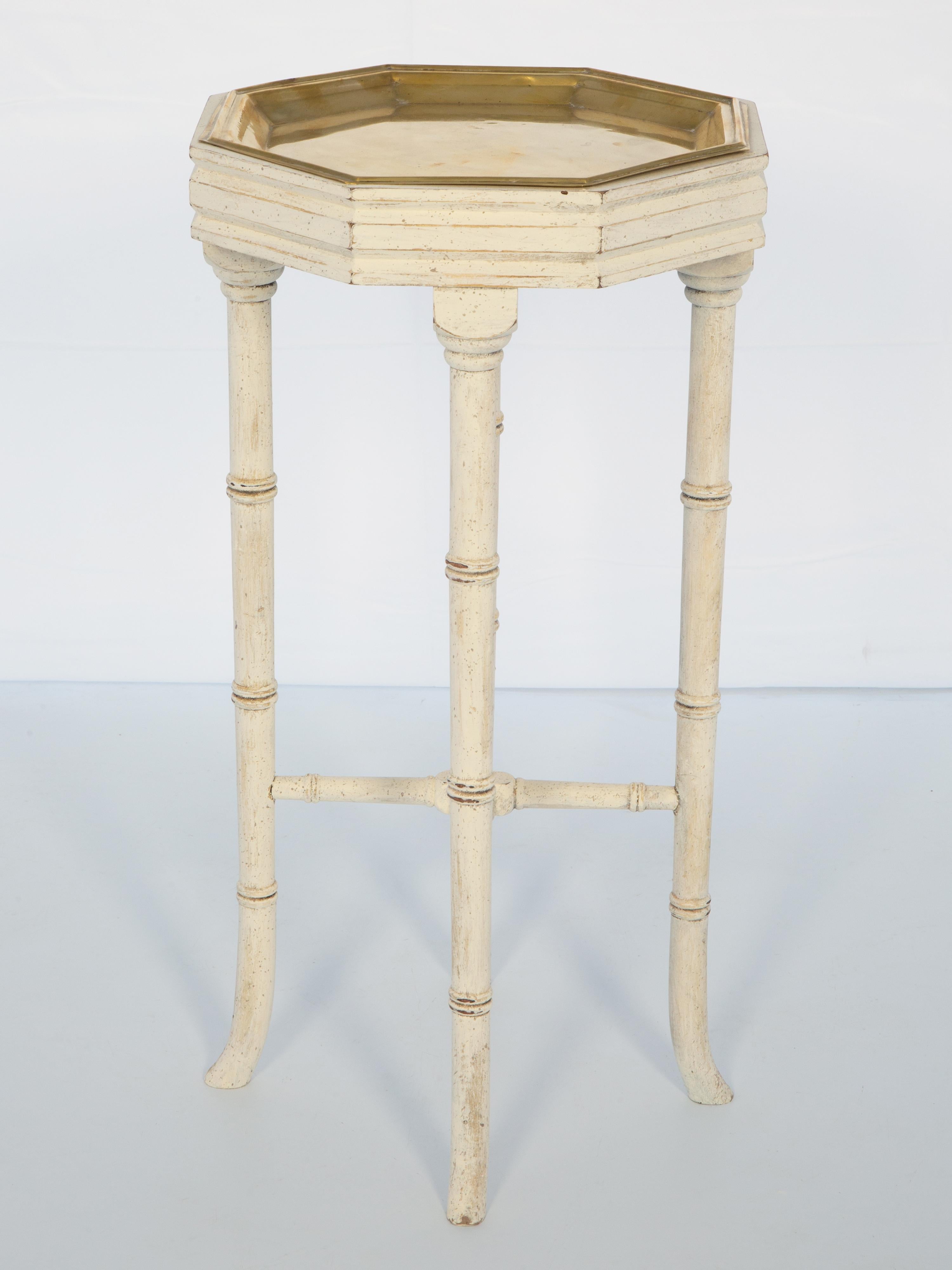 Table d'appoint Vintage, avec un plateau octogonal en laiton poli, sur une base de table en faux bambou avec une finition décapée, reposant sur des pieds ronds reliés par une traverse centrée par un fleuron en forme de gland en laiton, se terminant