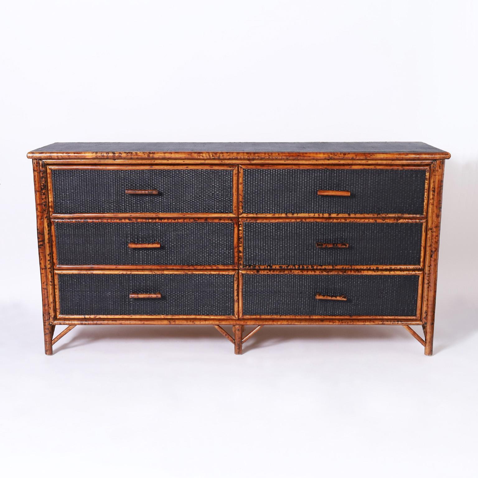 British Colonial style midcentury chest with six drawers crafted with a faux burnt bamboo frame and painted grasscloth panels on the top, sides and front and five legs with Asian Style brackets.