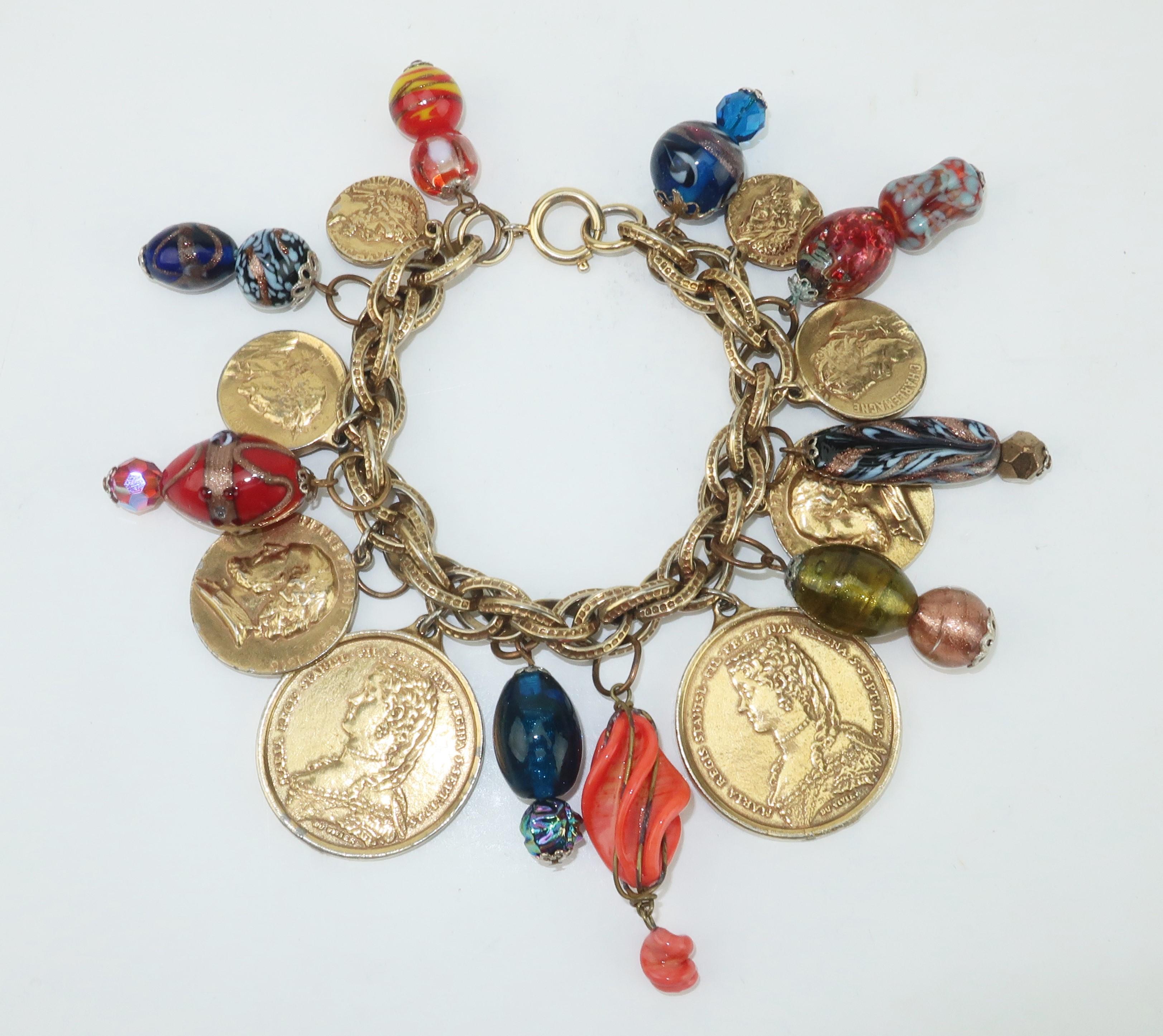 Charming!  Create lovely sound effects with this gold tone charm bracelet accented by European style coins and art glass beads that appear to be a mix of Bohemian and Murano.  Outfitted with spring ring closure marked ‘Germany’.  
CONDITION
Good