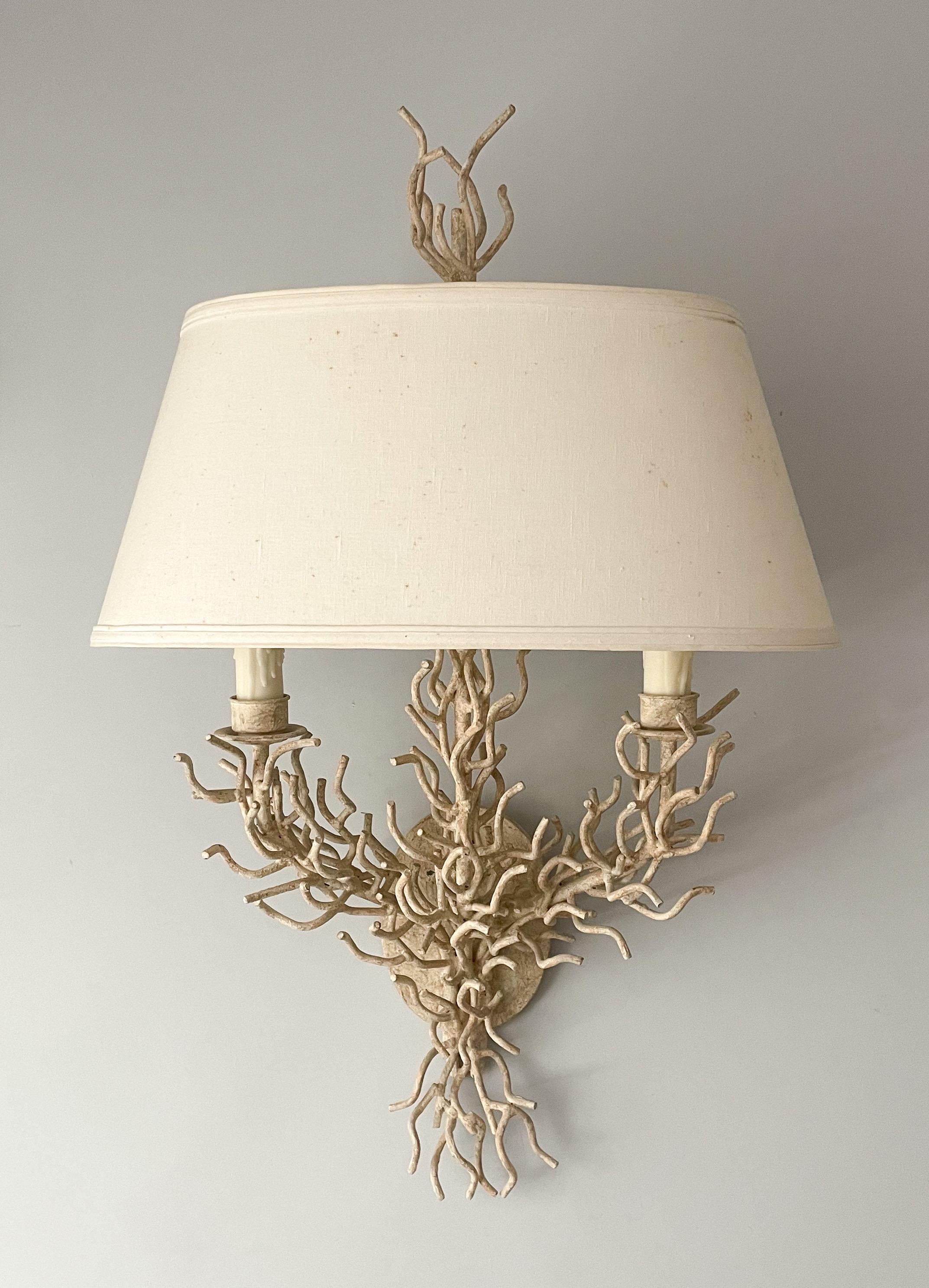 Fabulous, 1970s faux coral sconce with shade.

The sconce consists of a solid wrought iron frame in the form of two coral branches with a textured antiqued white paint finish. Original cloth shade and matching finial are included. The sconce is