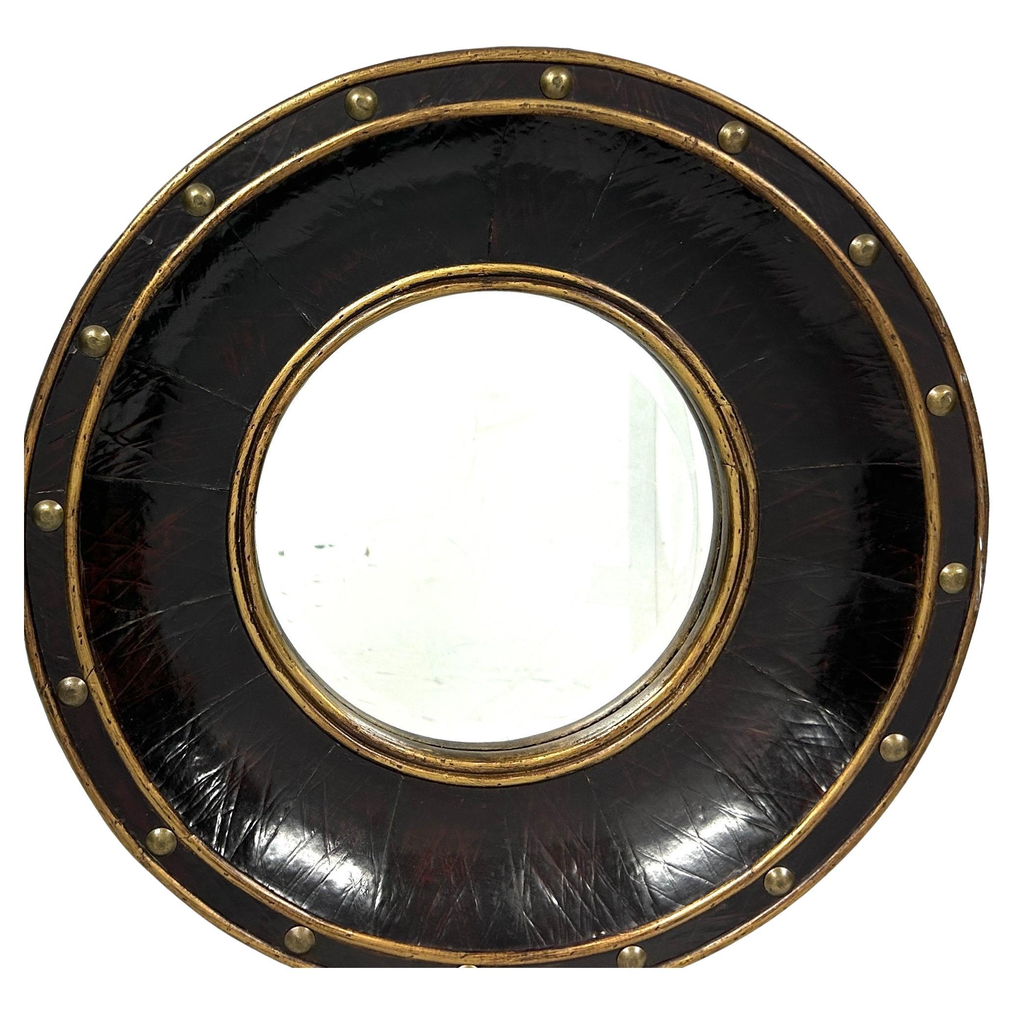 20th Century vintage faux leather round bullseye mirror with brass studs and trim. Mirror has a brown 2.5 inch frame and is in good shape without tarnish or de-silvering.