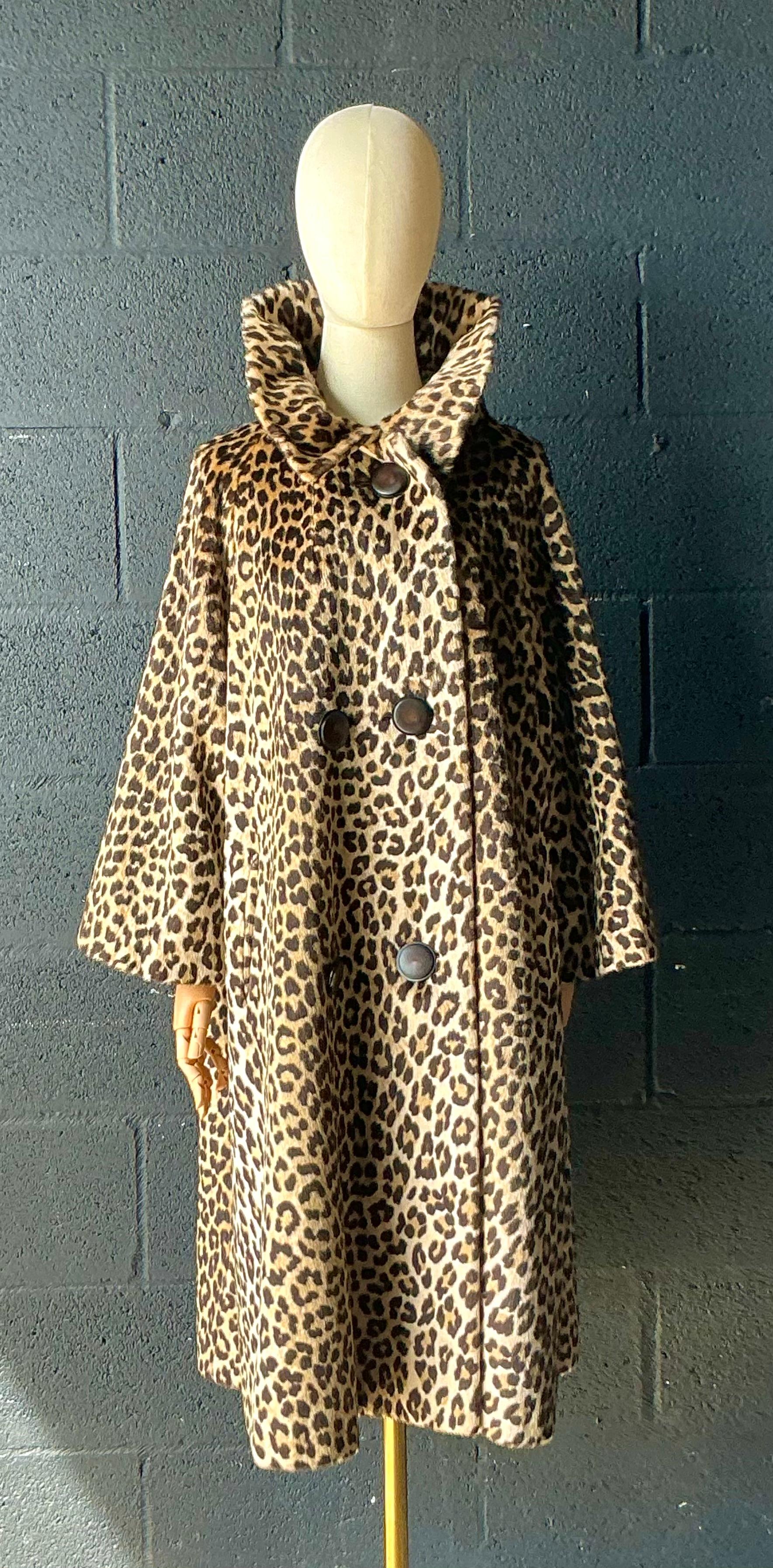 Questo cappotto vintage in finto leopardo è un pezzo intramontabile che emana fascino e raffinatezza retrò. Realizzato in morbida pelliccia sintetica di alta qualità, cattura il fascino audace della stampa leopardata rimanendo cruelty-free e comodo