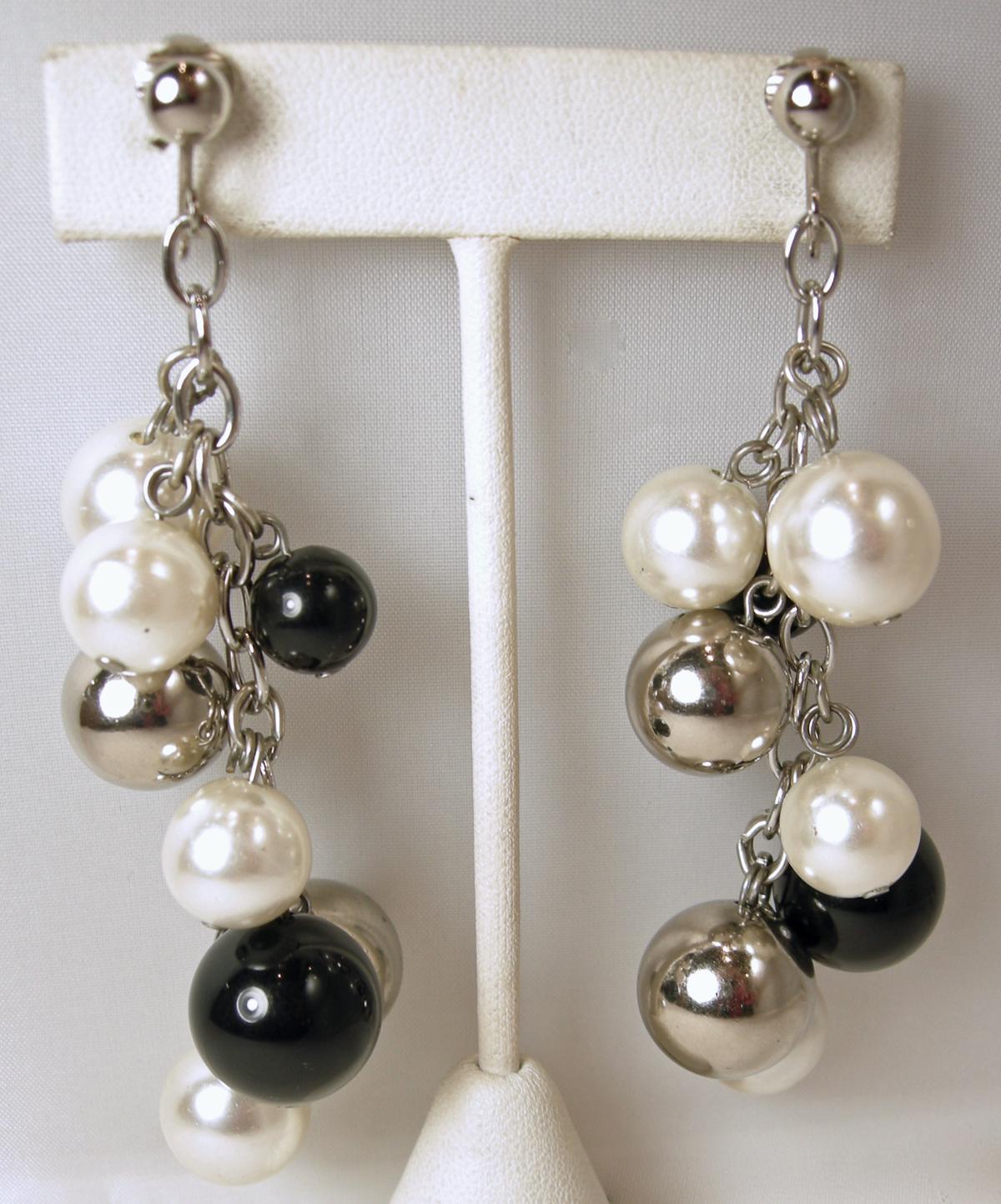 These vintage long earrings have faux pearls with black and silver tone beads streaming downward connected to a silver tone chain. In excellent condition, these clip earrings measure 3-1/2” x approx 1”.