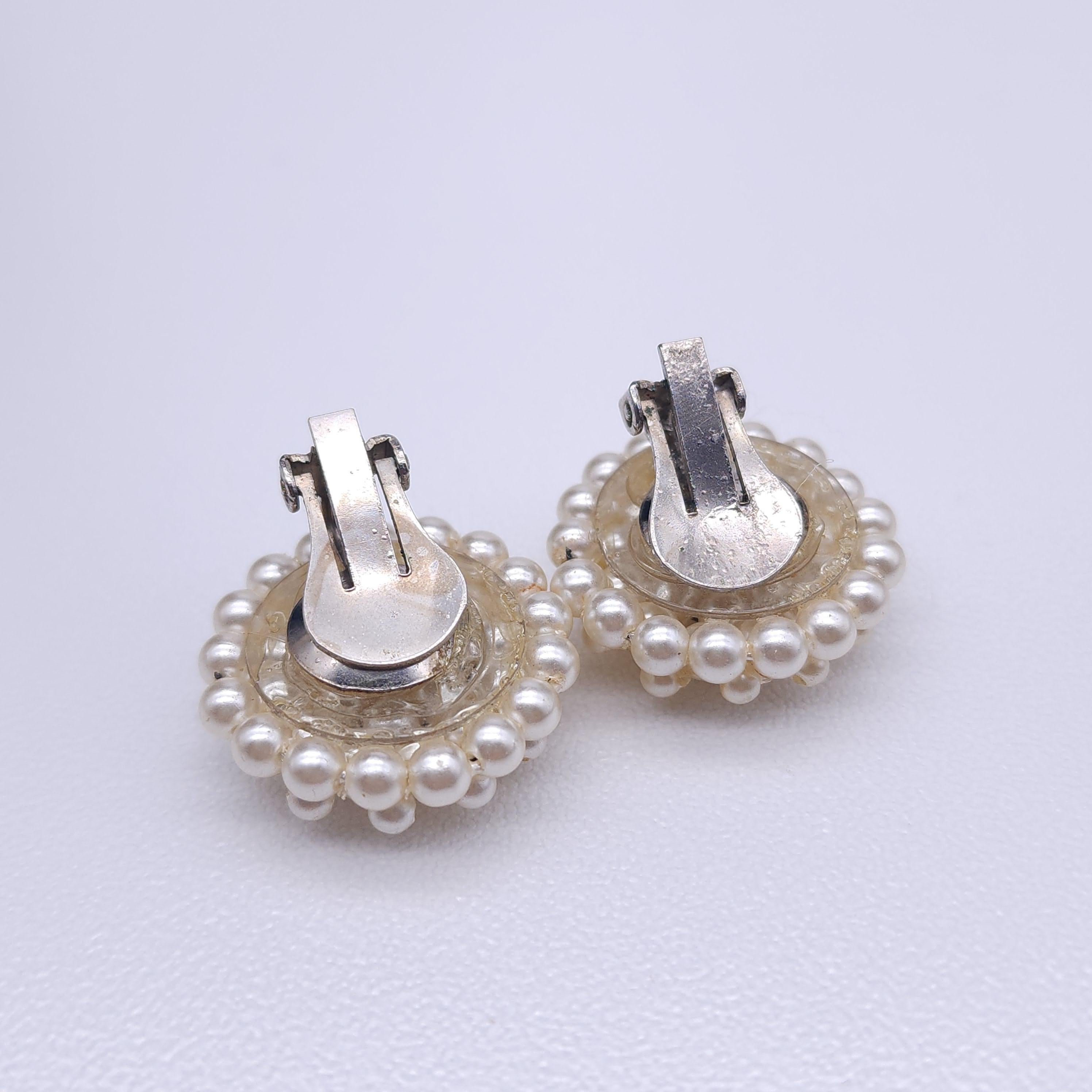 These charming vintage faux pearl clip-on earrings feature a domed cluster of ivory-colored pearls arranged in an elegant and timeless design. Perfect for adding a touch of vintage glamour, these earrings are ideal for both everyday wear and special