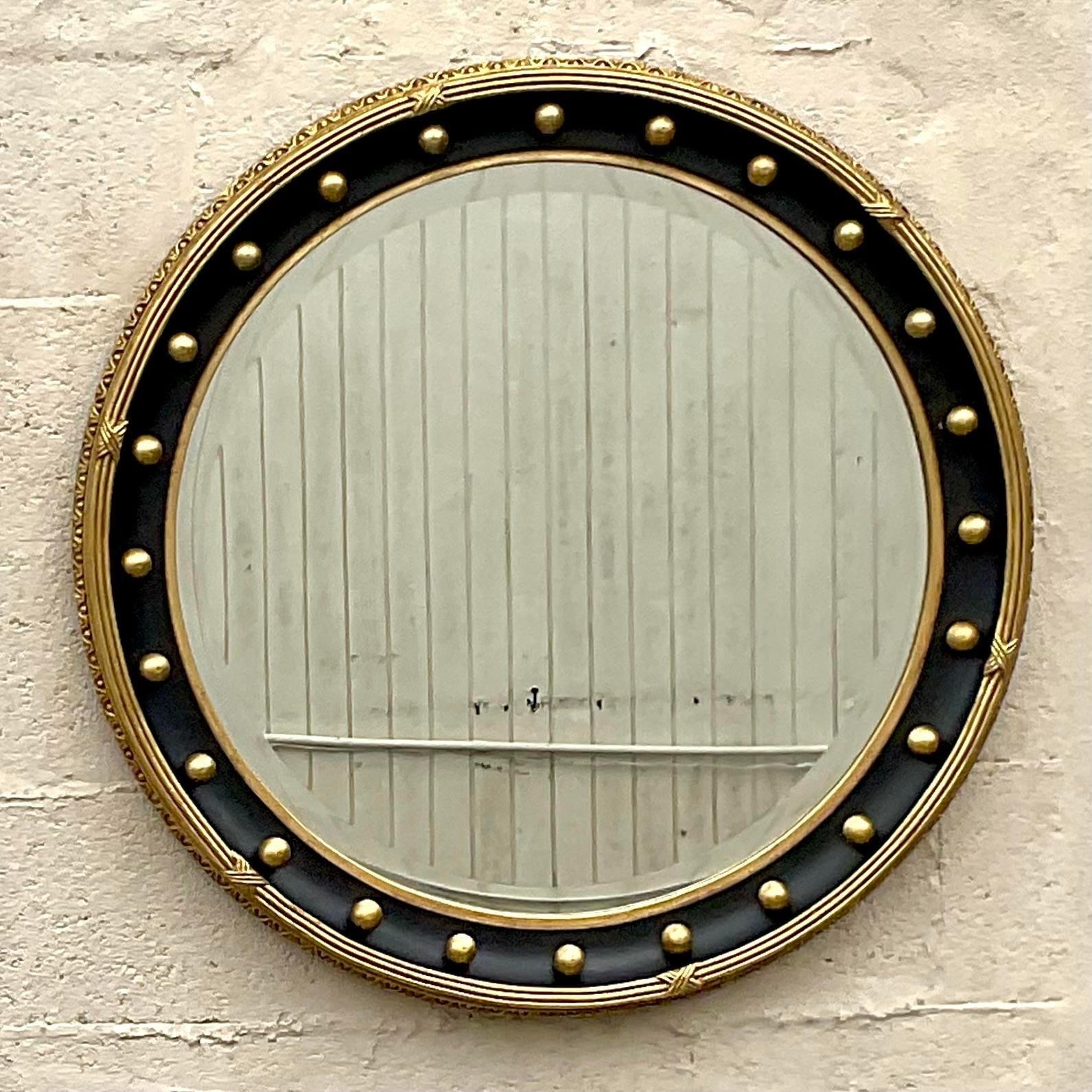A fabulous vintage Federal wall mirror. A chic round gilt parcel style with classic raised details. Two mirrors available as a pair is needed. Acquired from a Palm Beach estate.