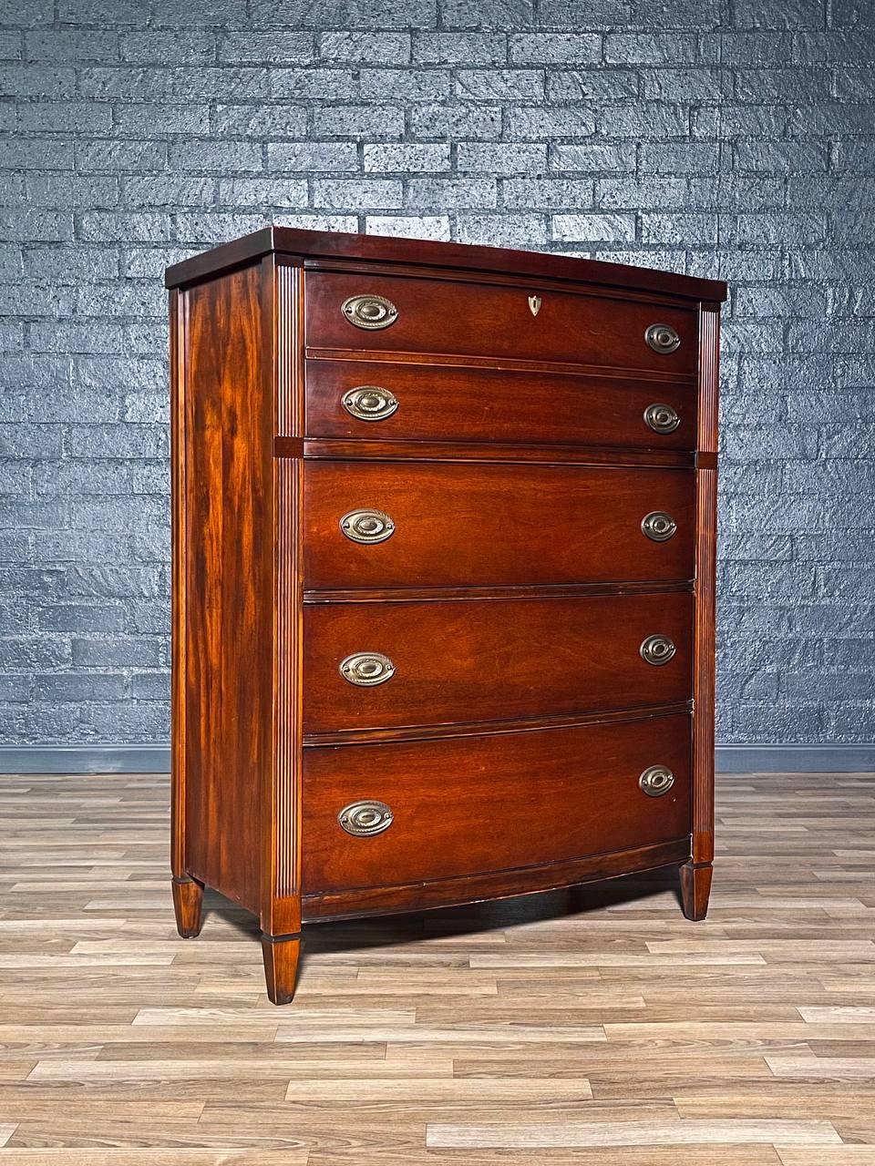 Condition: Original Vintage Condition

Materials: Mahogany, Patinated Brass Pull
Style: Federal Revival

Crafted in the 1950s, this Federal Revival highboy dresser showcases the elegance and symmetry characteristic of early American design. Built