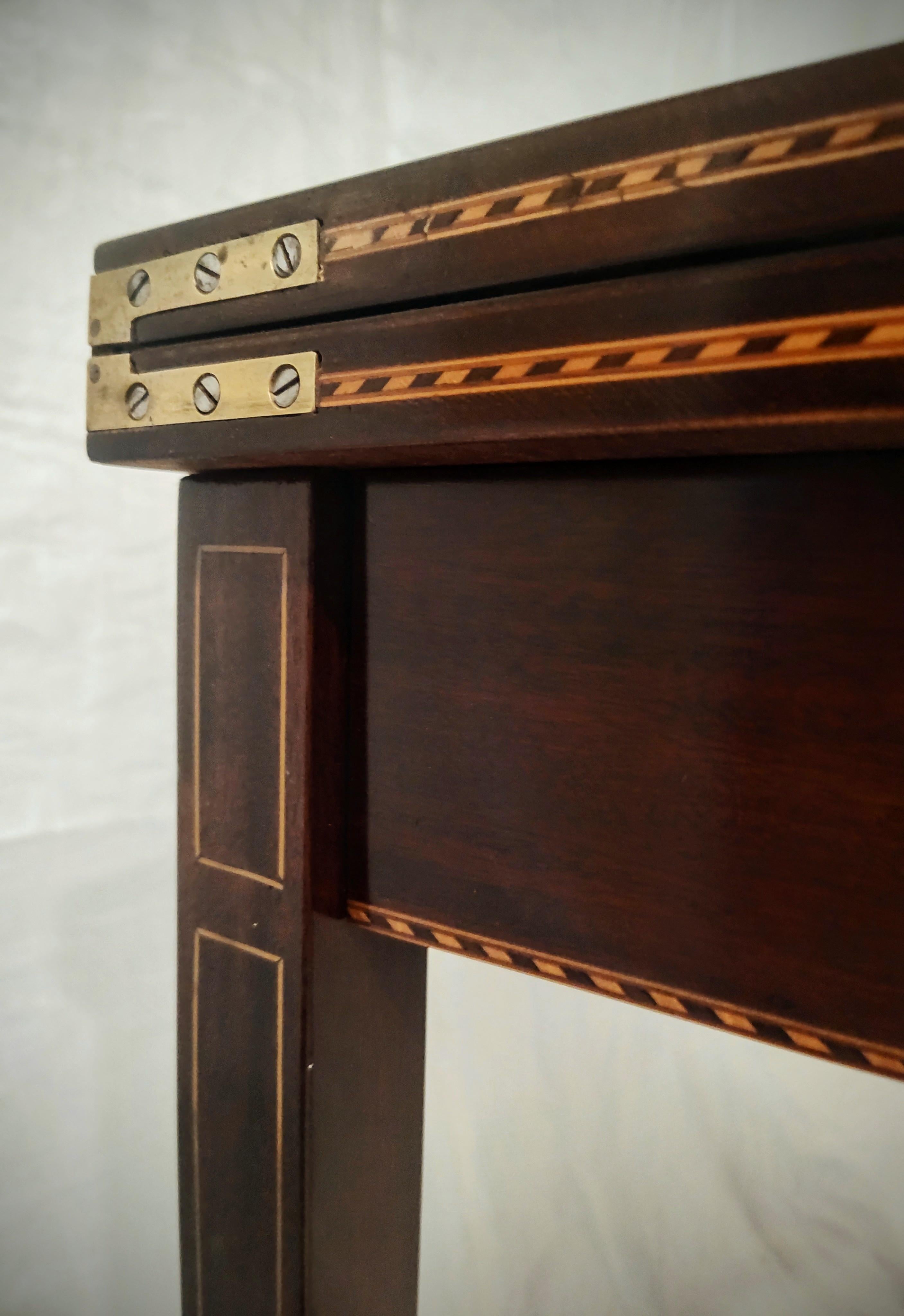 This vintage federal style game table is like a tribute to the Hepplewhite Style with its elegantly tapered legs, it's classic shape and it's abundance of inlays. The rich mahogany tones contrast wonderfully with the herringbone inlays around the