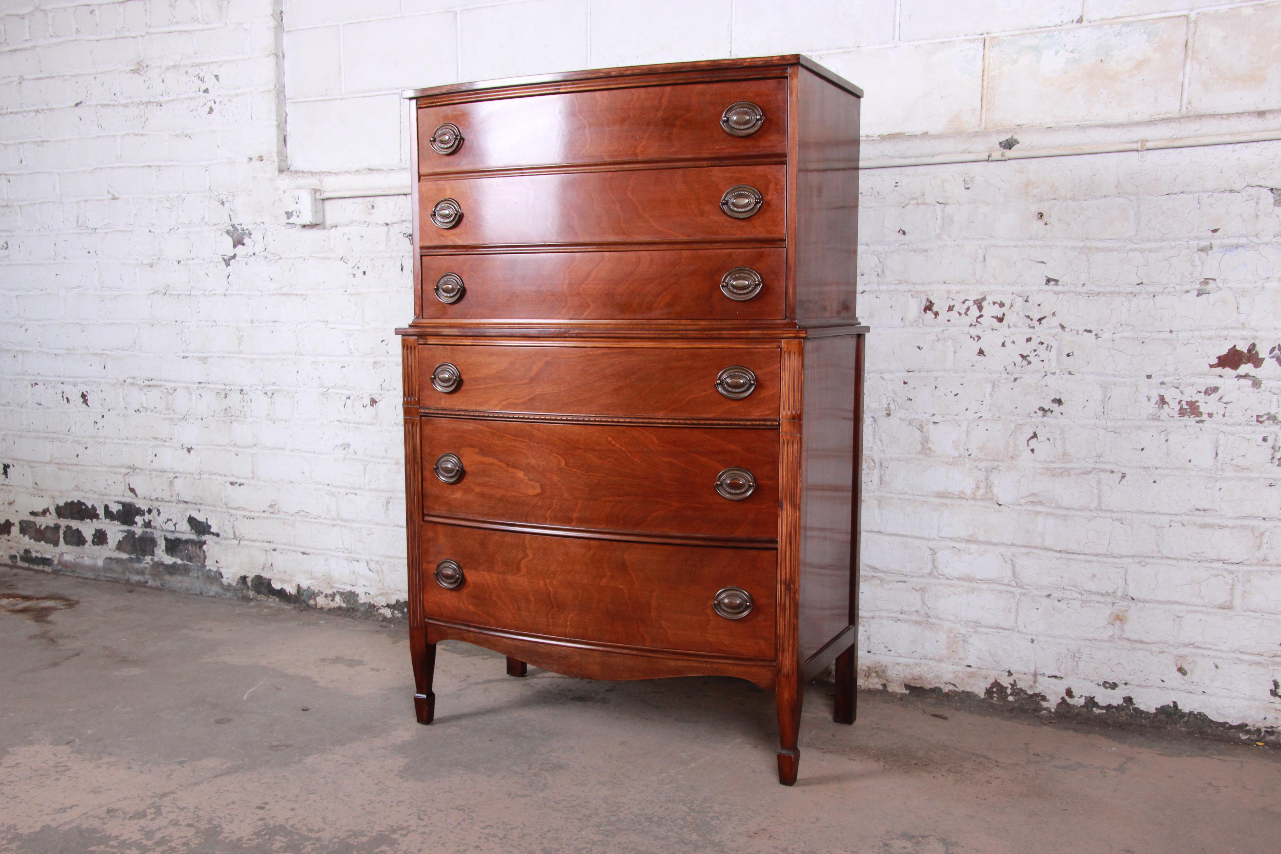 A very nice vintage Federal style mahogany highboy dresser. The dresser features gorgeous mahogany wood grain and a classic traditional style. It offers ample storage, with six deep dovetailed drawers. All hardware is original. The dresser is in