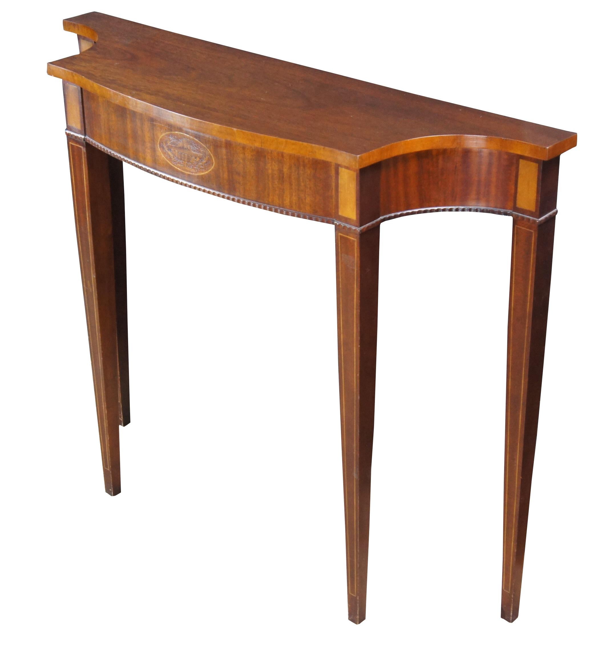 1970er Jahre American Federal Style Demilune Console Table, Councill Furniture zugeschrieben.  Der formschöne Mahagoni-Rahmen mit konkaven Ecken wird von einer mit Intarsien verzierten Urne, einer Sägezahnkante und quadratischen, konischen Beinen