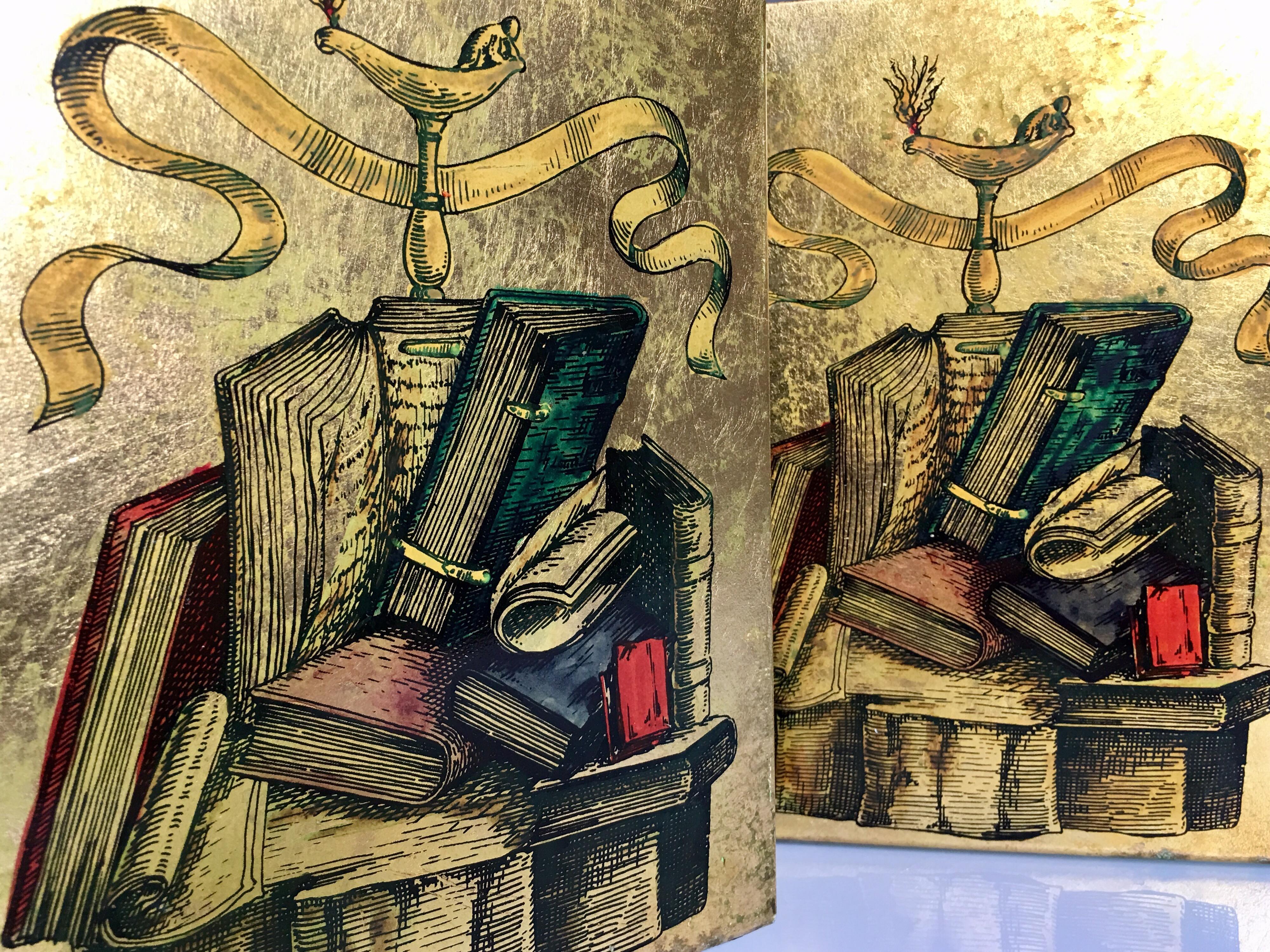 Probably dating to the 1970s, these metal bookends depict collections of books and scrolls with swag design atop. They are printed design and hand colored. Very similar to the Classic designs of Piero Fornasetti.