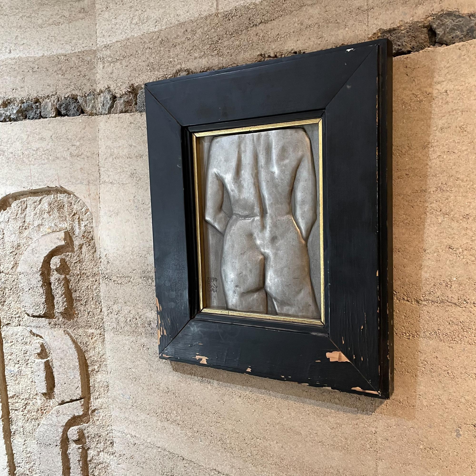 Vintage Female Nude Torso of backside hanging wall art in cast aluminum metal. Painted-patinated. 
Wood frame in Black. Paint flaking off. Art work signed bottom left with numerals.
Measures: 21.13 Tall x 17.5W x 1.63 D art 12.75 x 9 W
Unrestored