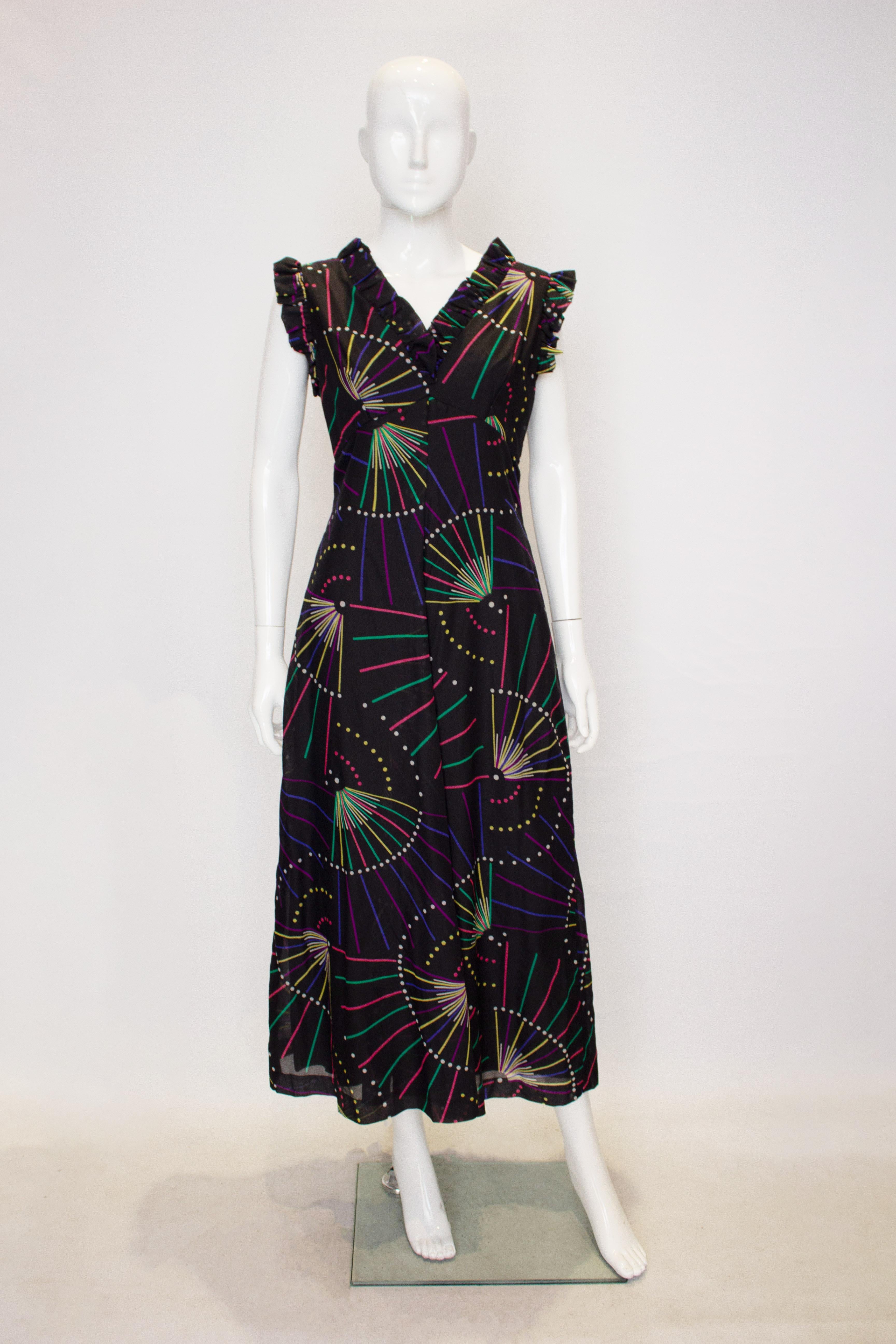 A great vintage party dress by Feminette. The dress has a v neckline and backline with frill detail.
It has a black background with pink, yellow  green and white detail.  The dress is fully lined and has a back central zip.