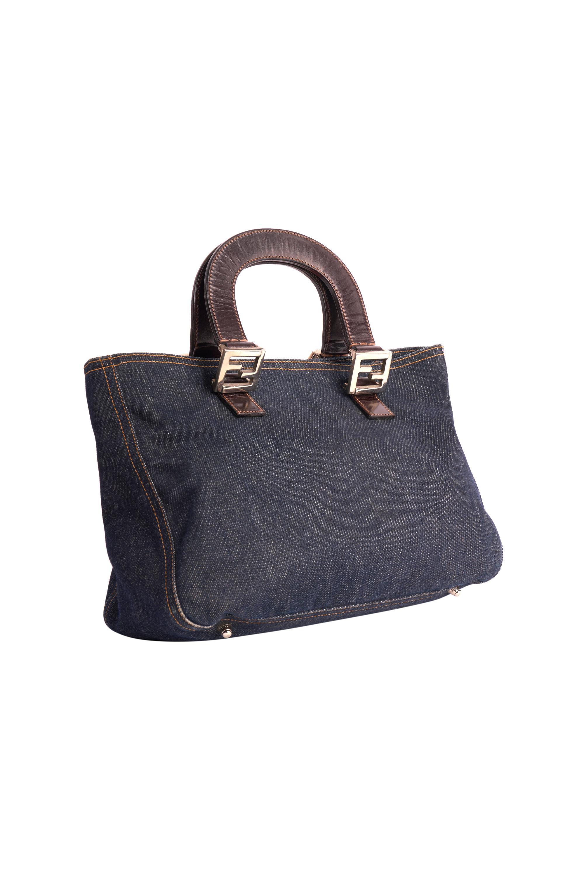 Mini bolso tote vaquero vintage Fendi de los años 90. Con cuerpo de tela vaquera, asas superiores de piel marrón y herrajes plateados con el logotipo 