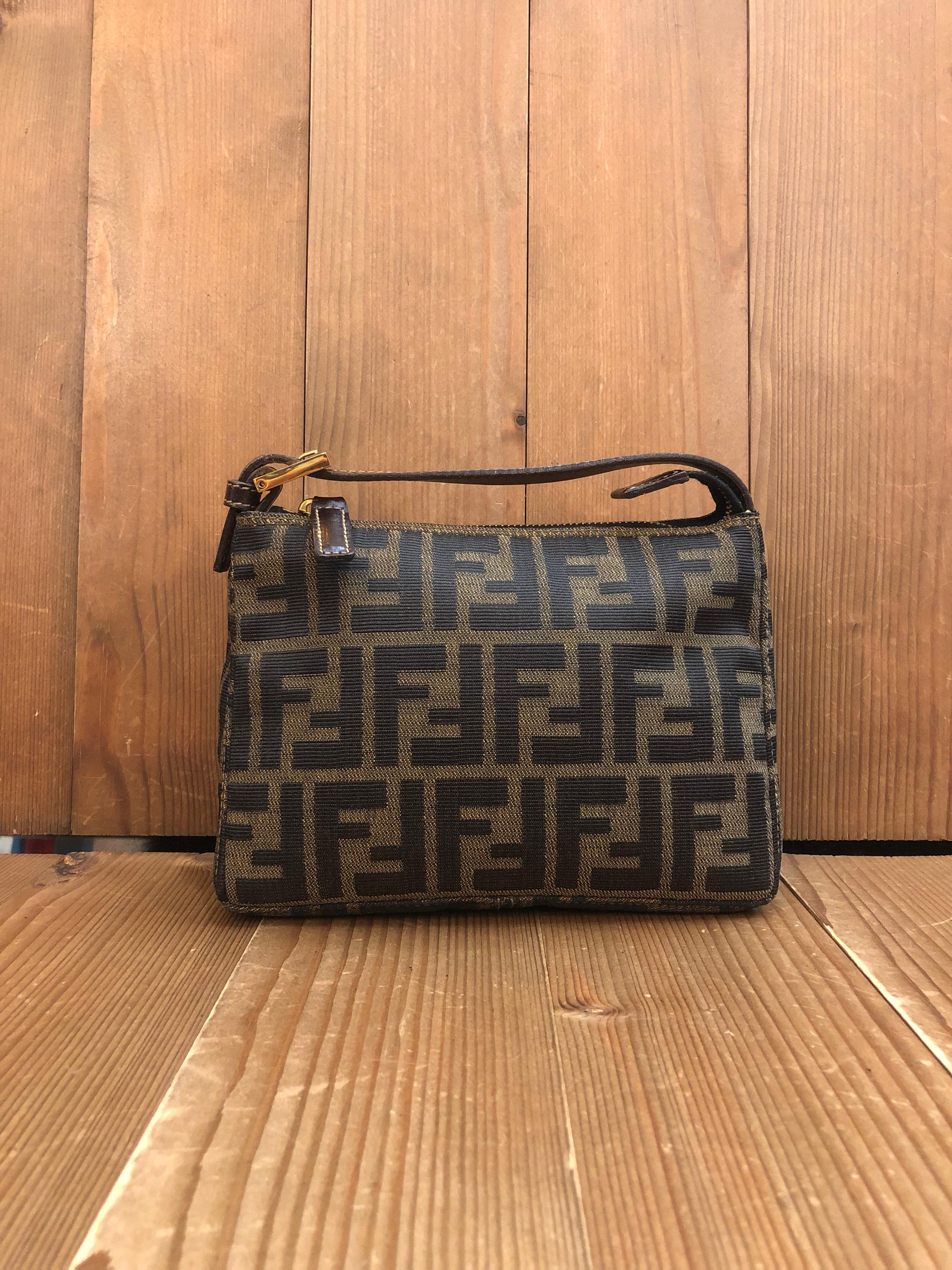 This vintage FENDI mini pouch handbag is crafted of Fendi's iconi Zucca jacquard in brown/black trimmed with brown leather featuring gold toned hardware. Zipper top closure opens to a new beige interior. Made in Italy. Measures 7.25 x 5.25 x 3