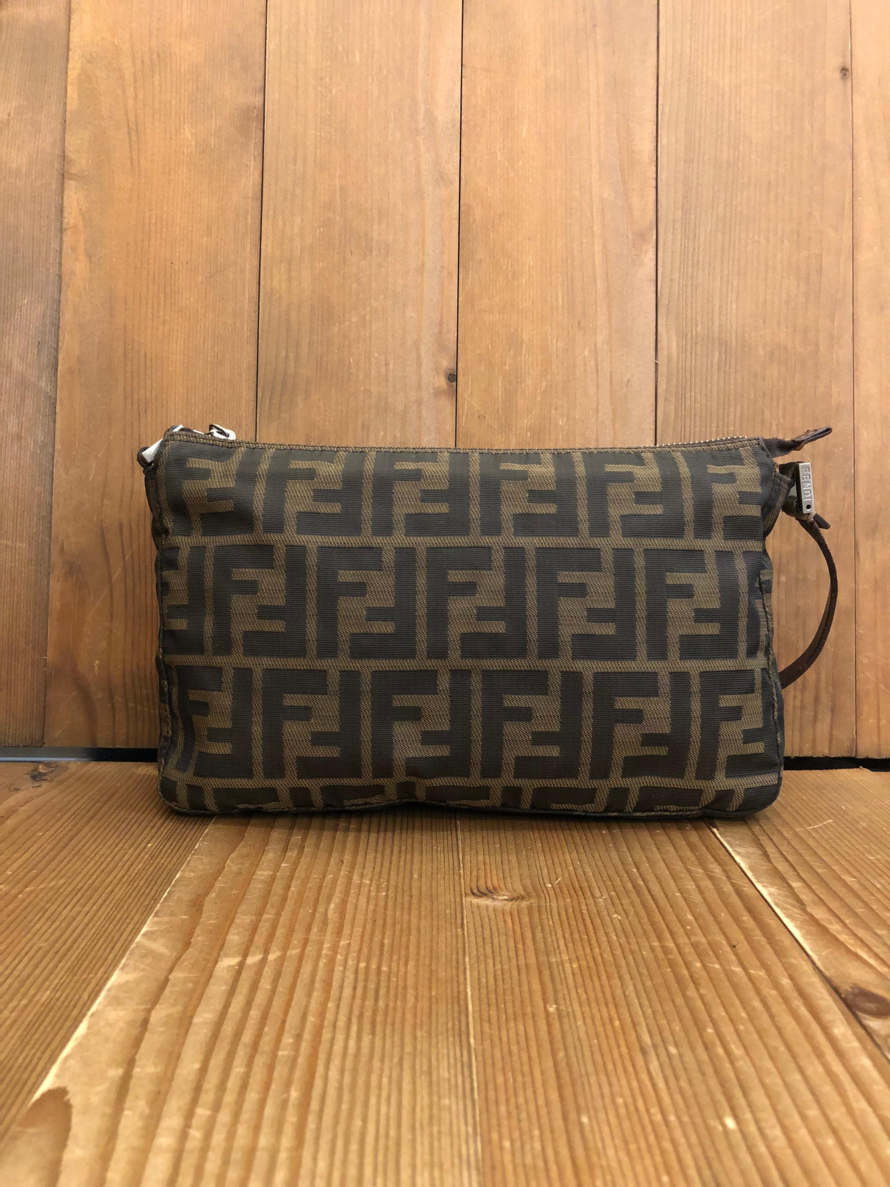 Vintage Fendi pouch handbag in Fendi's iconic brown Zucca jacquard with silver toned black enameled hardware. Zipper top closure opens to an interior lined with brown fabric featuring one zippered pocket. Made in Italy. Measures 9.5 x 6 x 1.75
