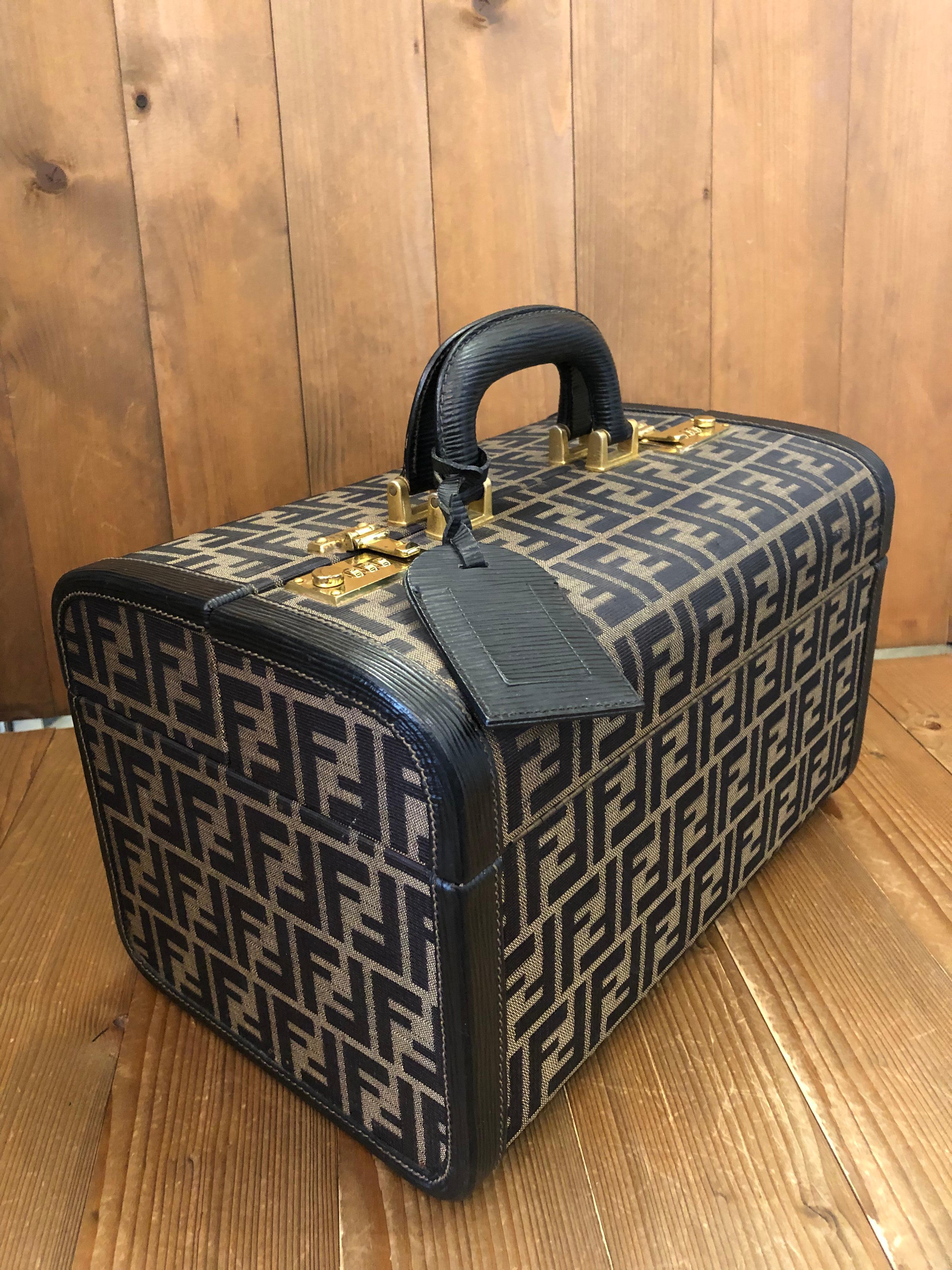 This Vintage FENDI vanity trunk case is crafted of Fendi’s signature brown FF Zucca jacquard and black leather. This trunk features sturdy leather handles and two combination locks for safeguarding your valuables. Front double-lock closure opens to