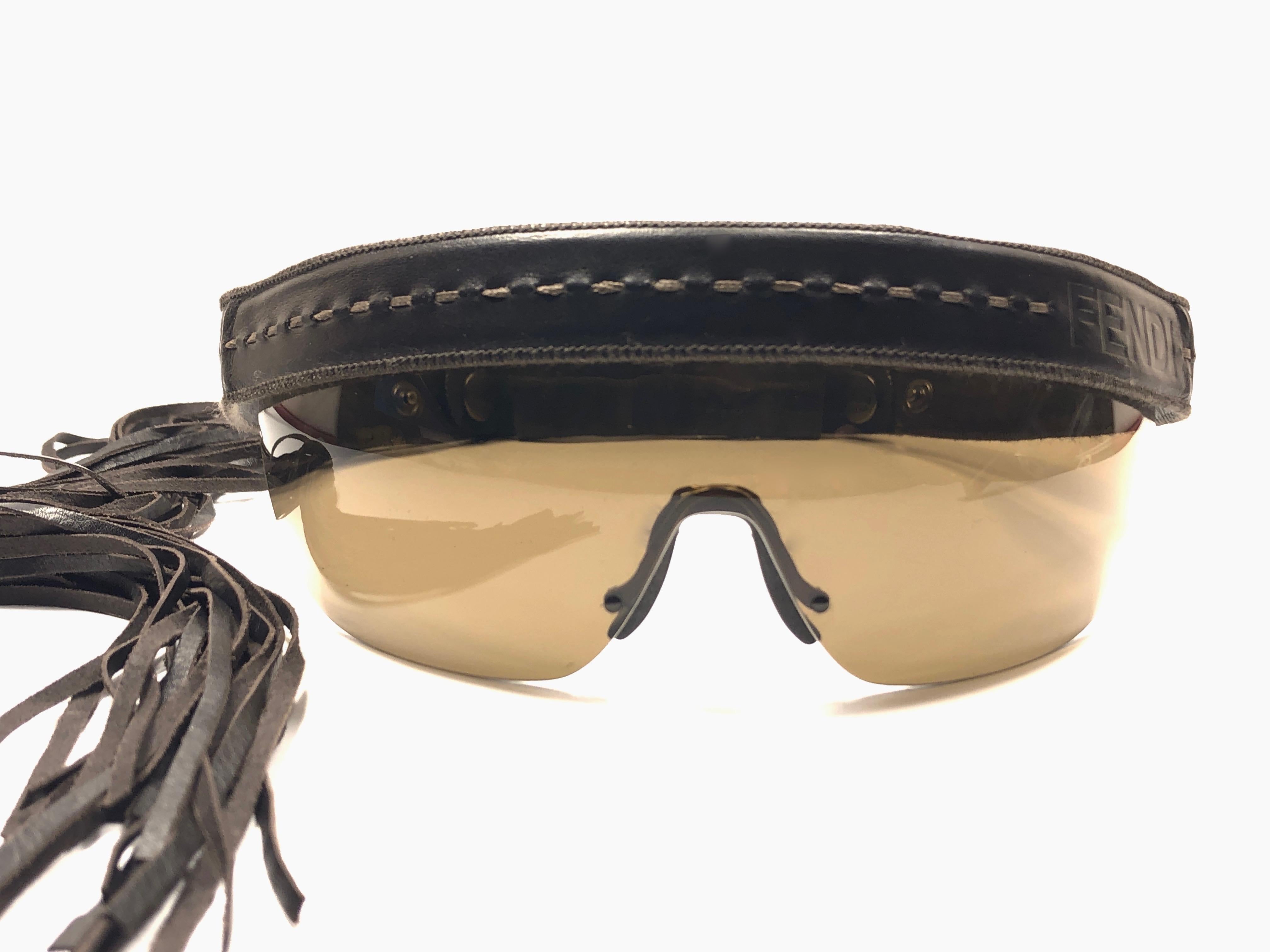 Vintage Fendi limited edition leather constructed frame features a leather headband with tassels and tinted lenses. 

This pair is marked “FS341L 81 21 200 135 Made in Italy.

Produced and design in 1990's.

This piece has light sign of wear on the