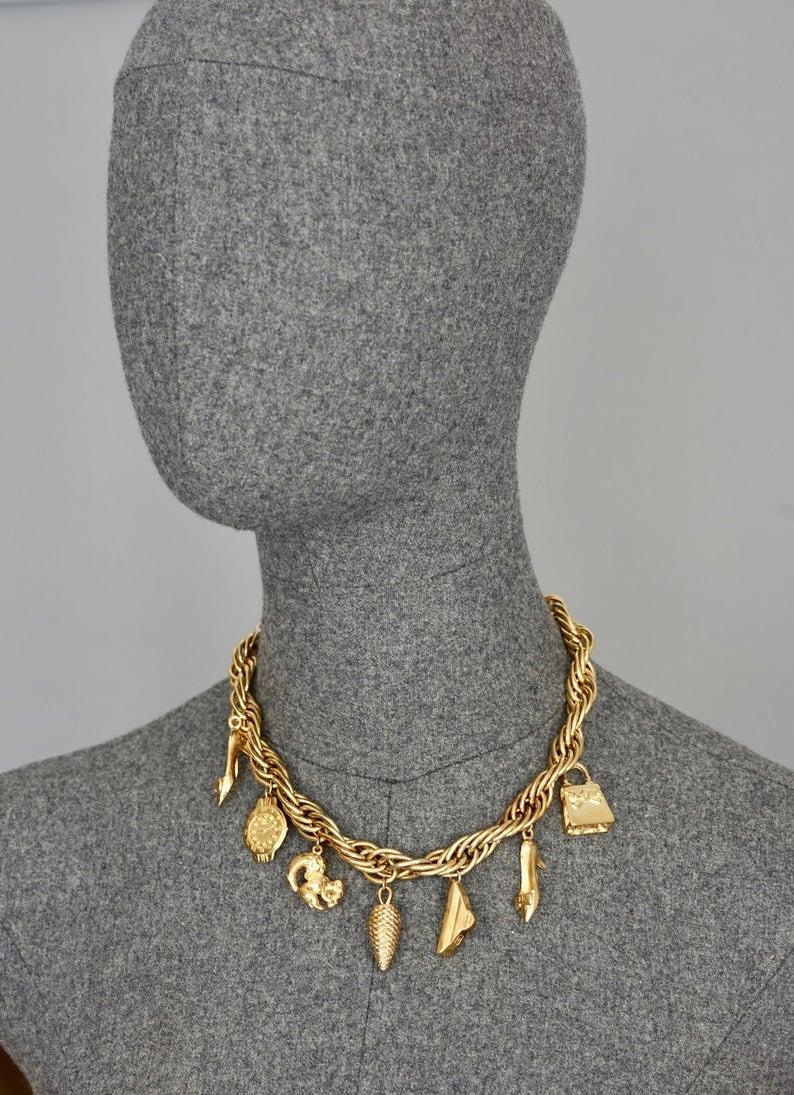 Vintage FENDI Iconic Charm Necklace

Measurements:
Wearable Length: 17 inches (43.18 cm)

Features:
- 100% Authentic FENDI.
- Chunky chain and charms in gold tone.
- 7 dangling charms: Watch, Pine Cone, Triangle, Squirrel, Kelly Bag, (2) High Heeled