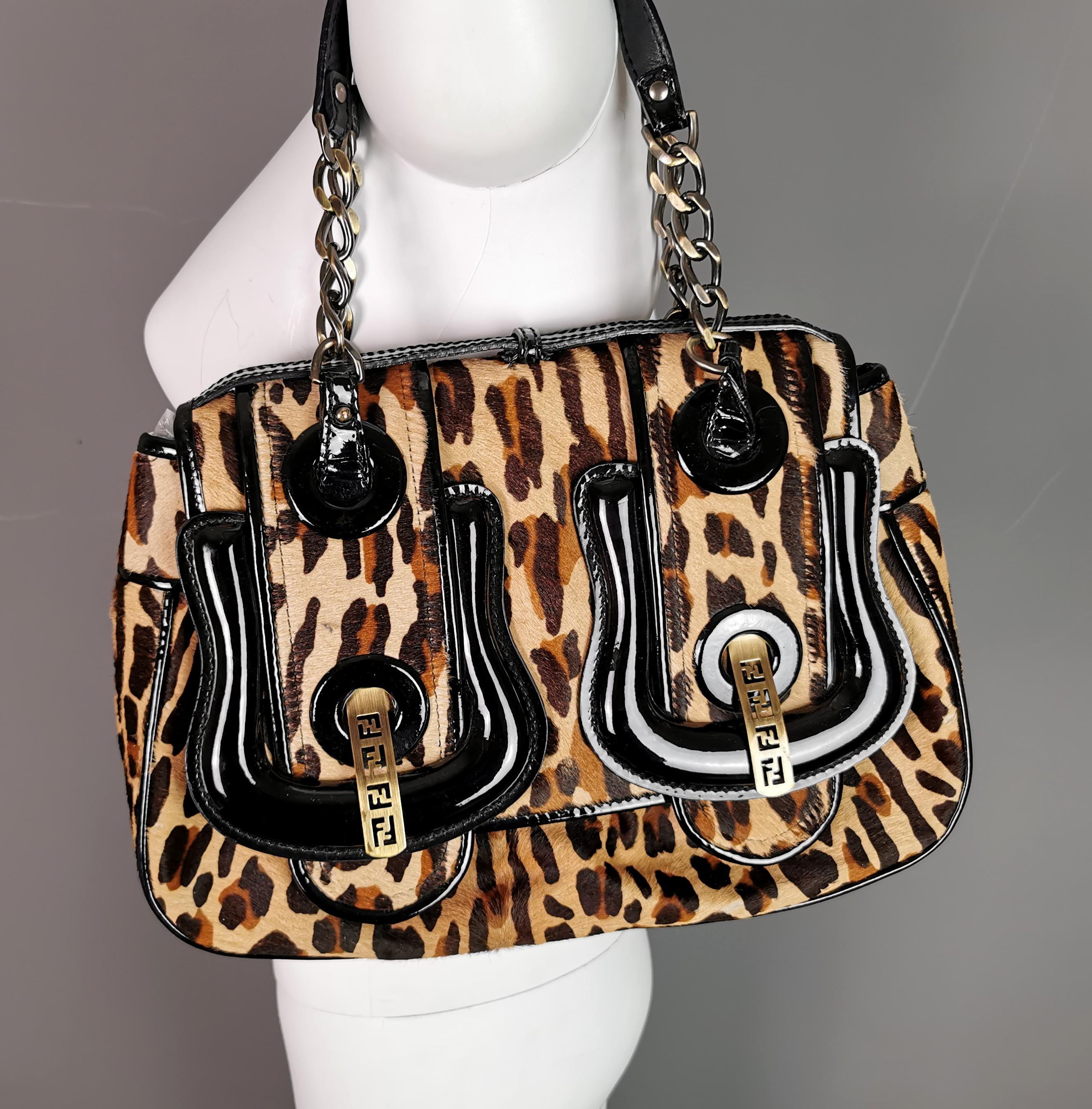 A truly stunning vintage Fendi leopard print, pony style calf skin B bag.

It has a lovely leopard print design with chunky black patent leather faux buckles to the front, the shiny black leather contrasting really well with the iconic leopard