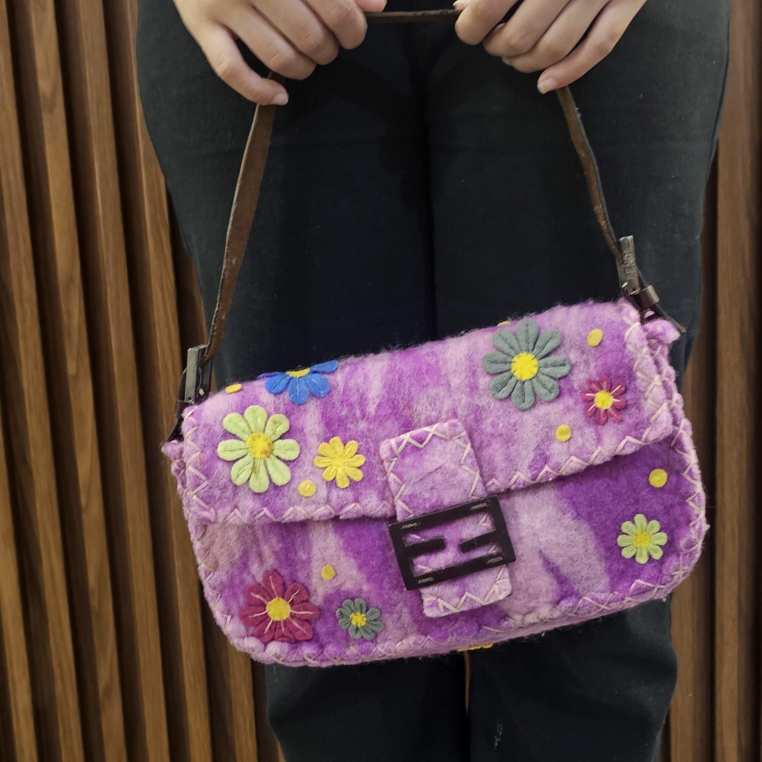 Fendi mama baguette vintage in lana rosa e viola con applicazioni floreali. Un design da collezione molto carino. In buone condizioni vintage, con una leggera sfogliatura e un ingiallimento in alcune parti del tessuto. C'è una crepa sulla tracolla