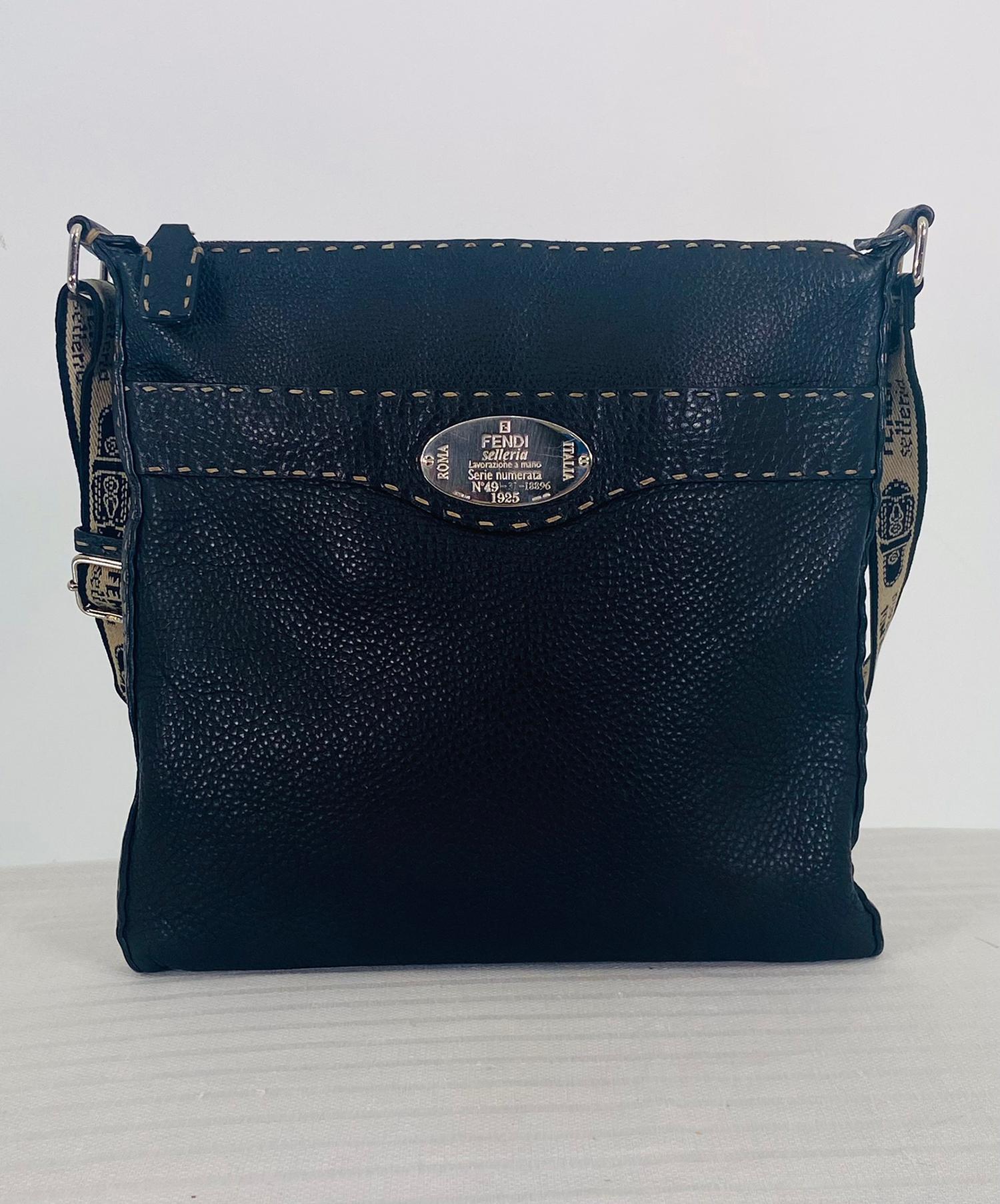 The rare and collectable FENDI selleria black leather cross body bag with logo canvas strap. Supple pebble leather body with the silver Selleria numbered tab has off white saddle stitching. The bag features a main zipped compartment that has a