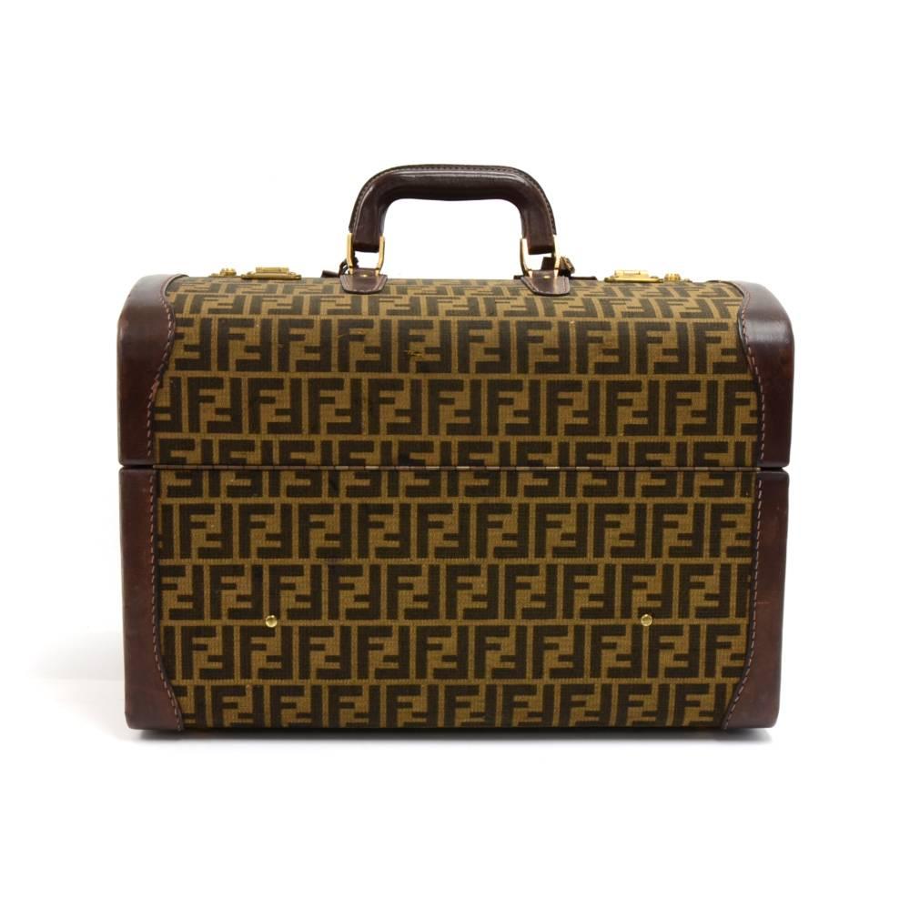 Vintage Fendi Tobacco Zucca Train case or Trunk in Jacquard fabric with brown leather trim. The outside features the classic Fendi logo print and has two locks on the top and metal feet to protect the bottom of the bag. The bag opens up from both